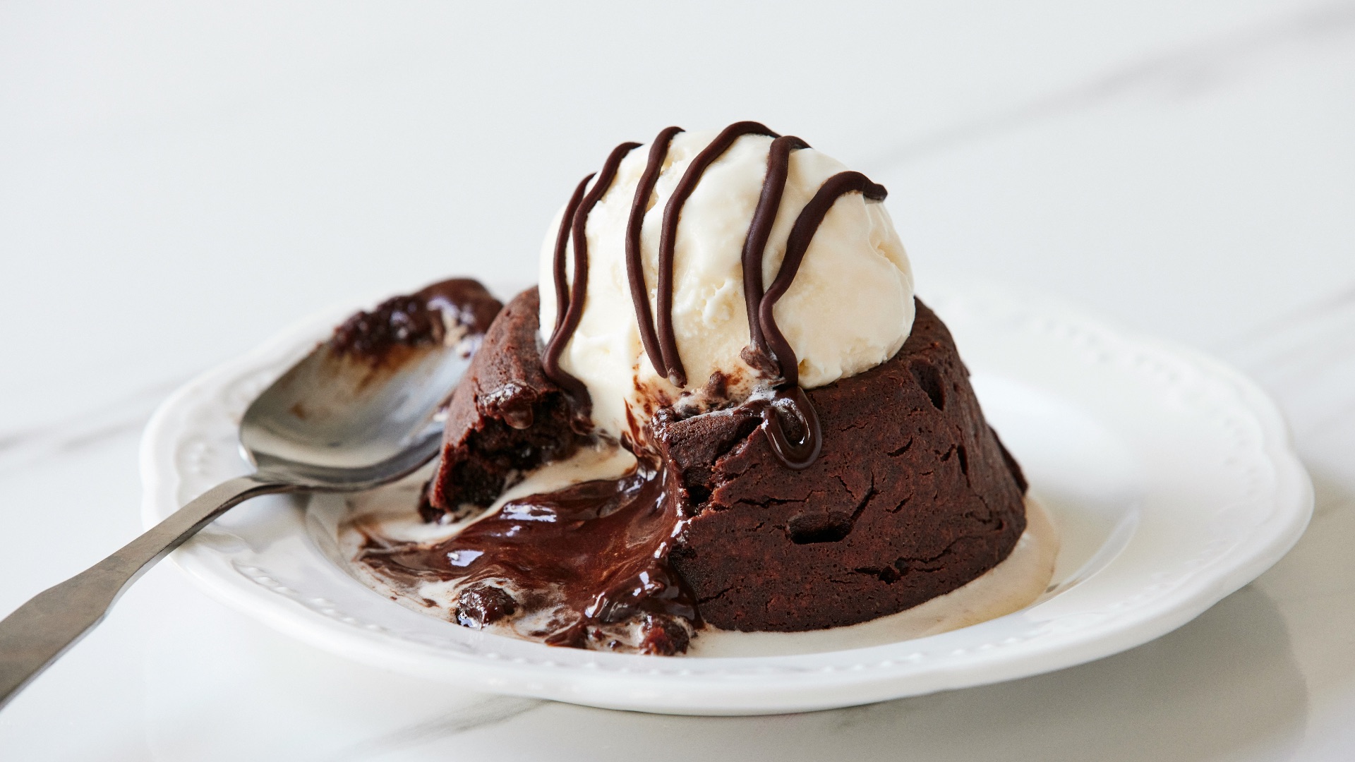 a white plate topped with a piece of cake and ice cream