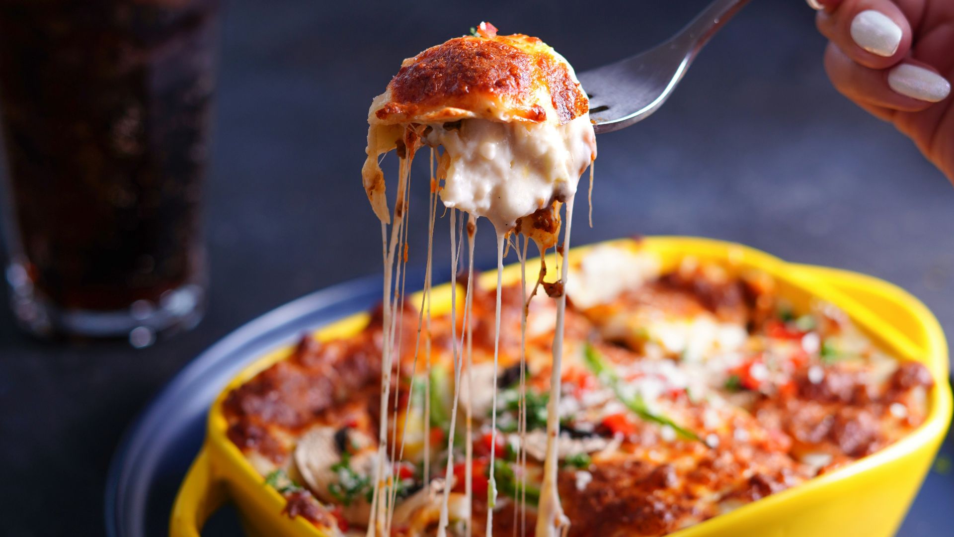 person holding stainless steel fork and yellow bowl with food