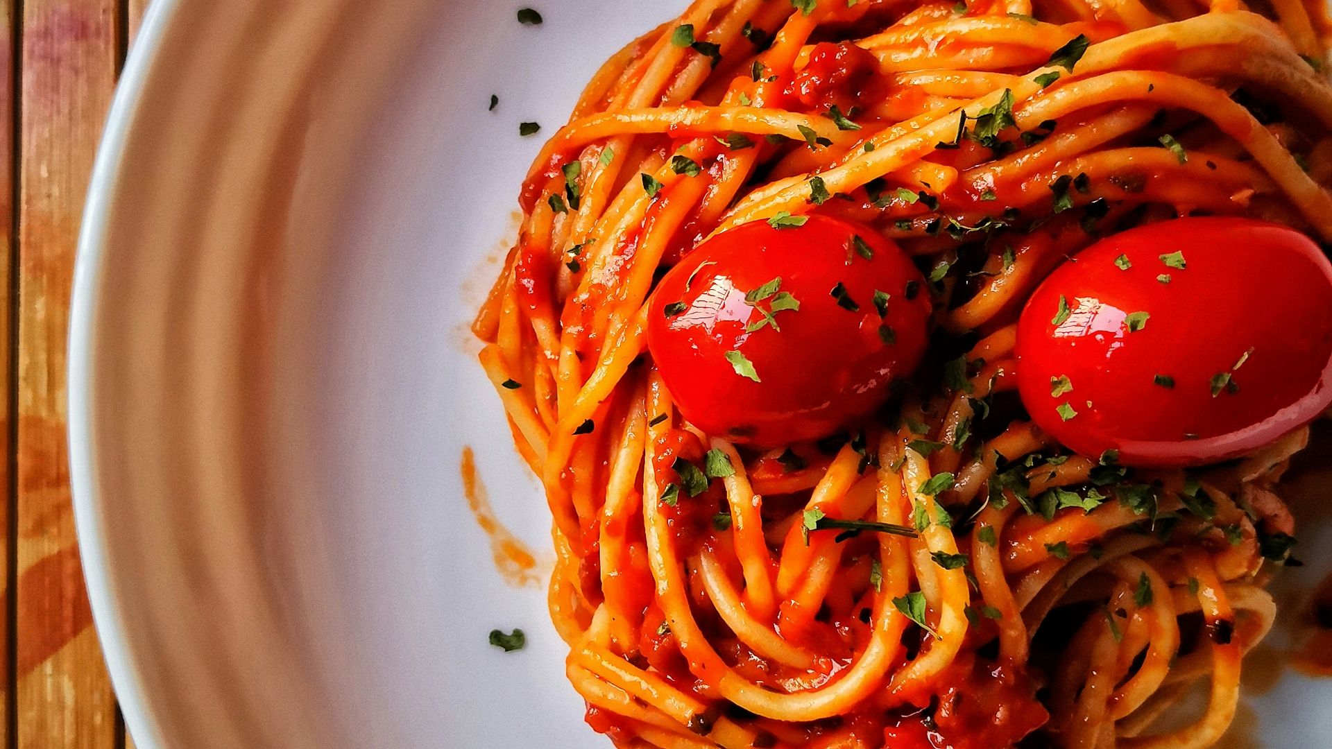 a white plate topped with spaghetti and tomatoes
