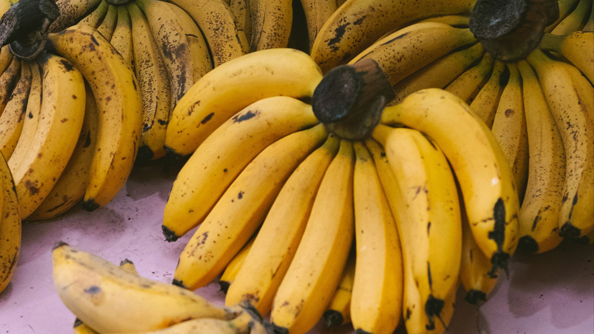 bunches of bananas are sitting on a table