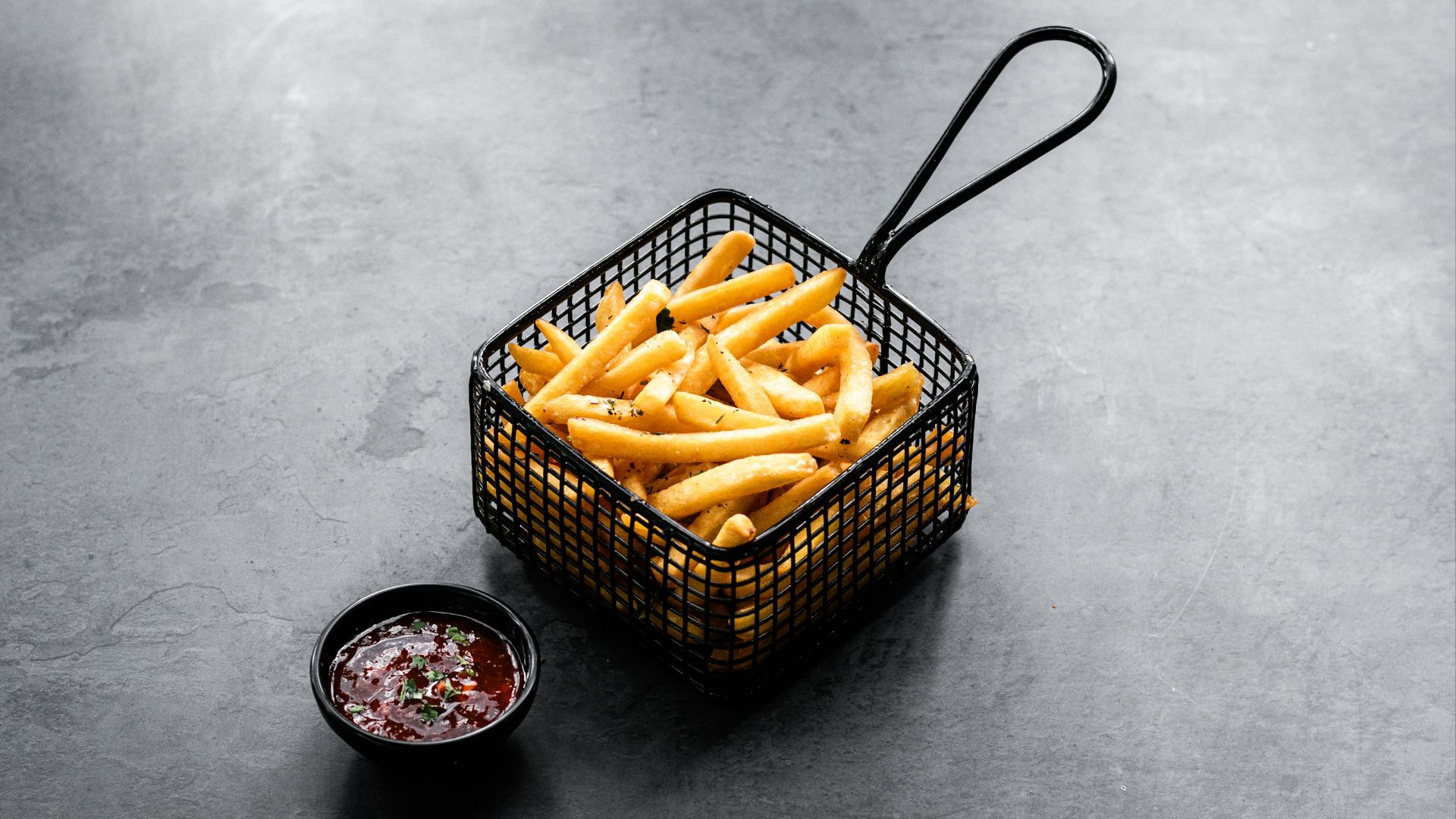 a basket filled with french fries next to a bowl of ketchup
