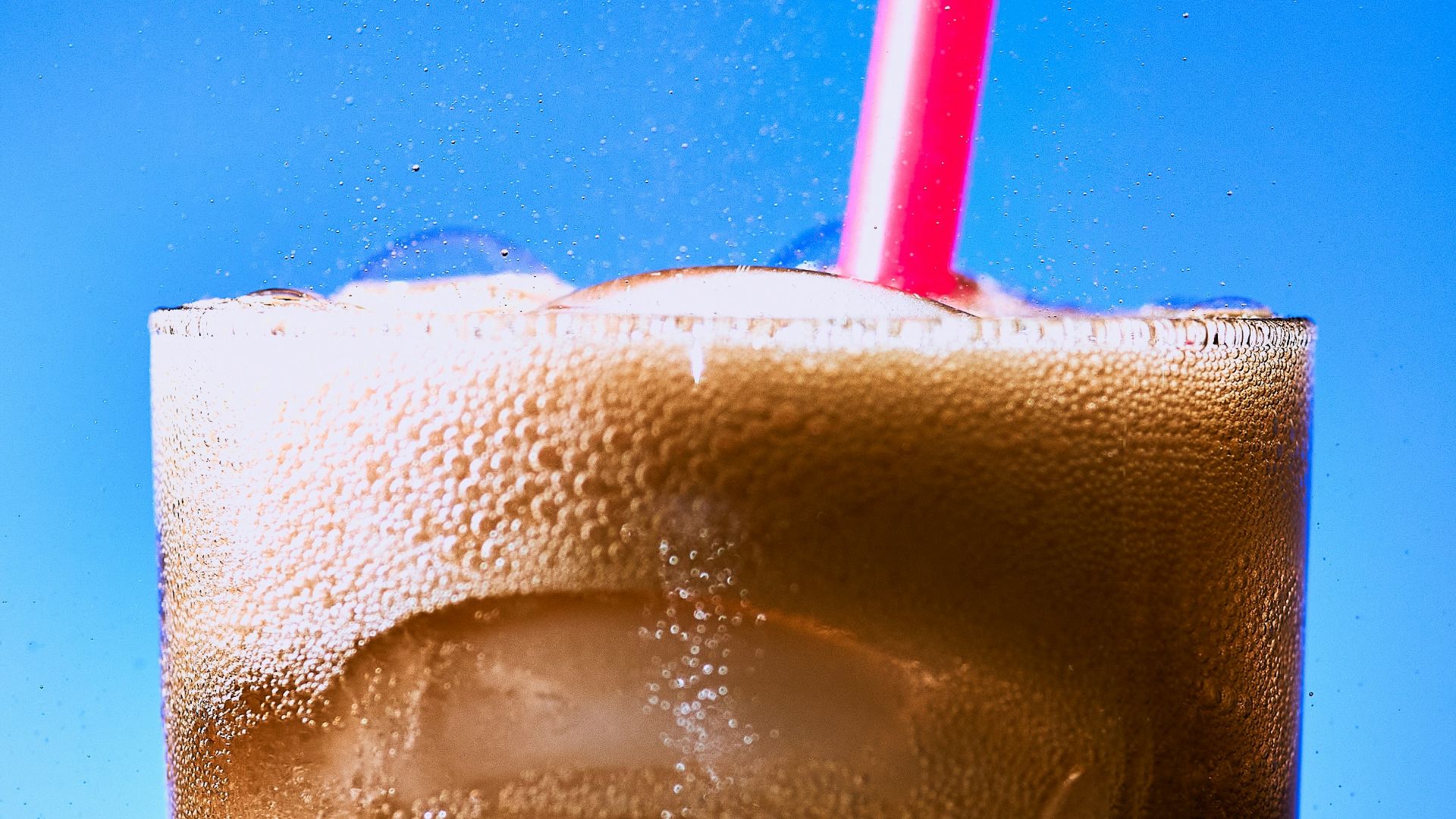 clear drinking glass with ice and red straw