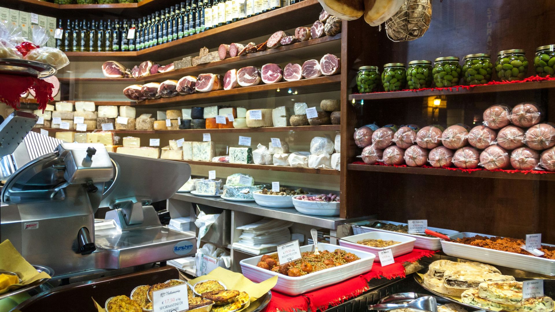 Deli counter filled with cheeses, meats, and prepared foods.