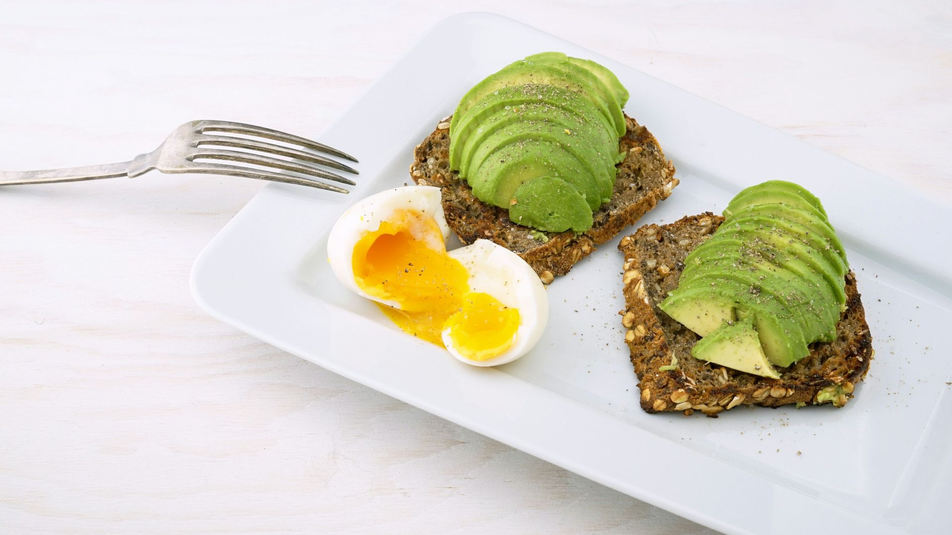 rectangular white platter of sliced food and eggs
