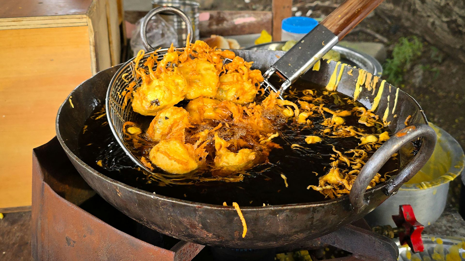 Fritters being fried in a large wok