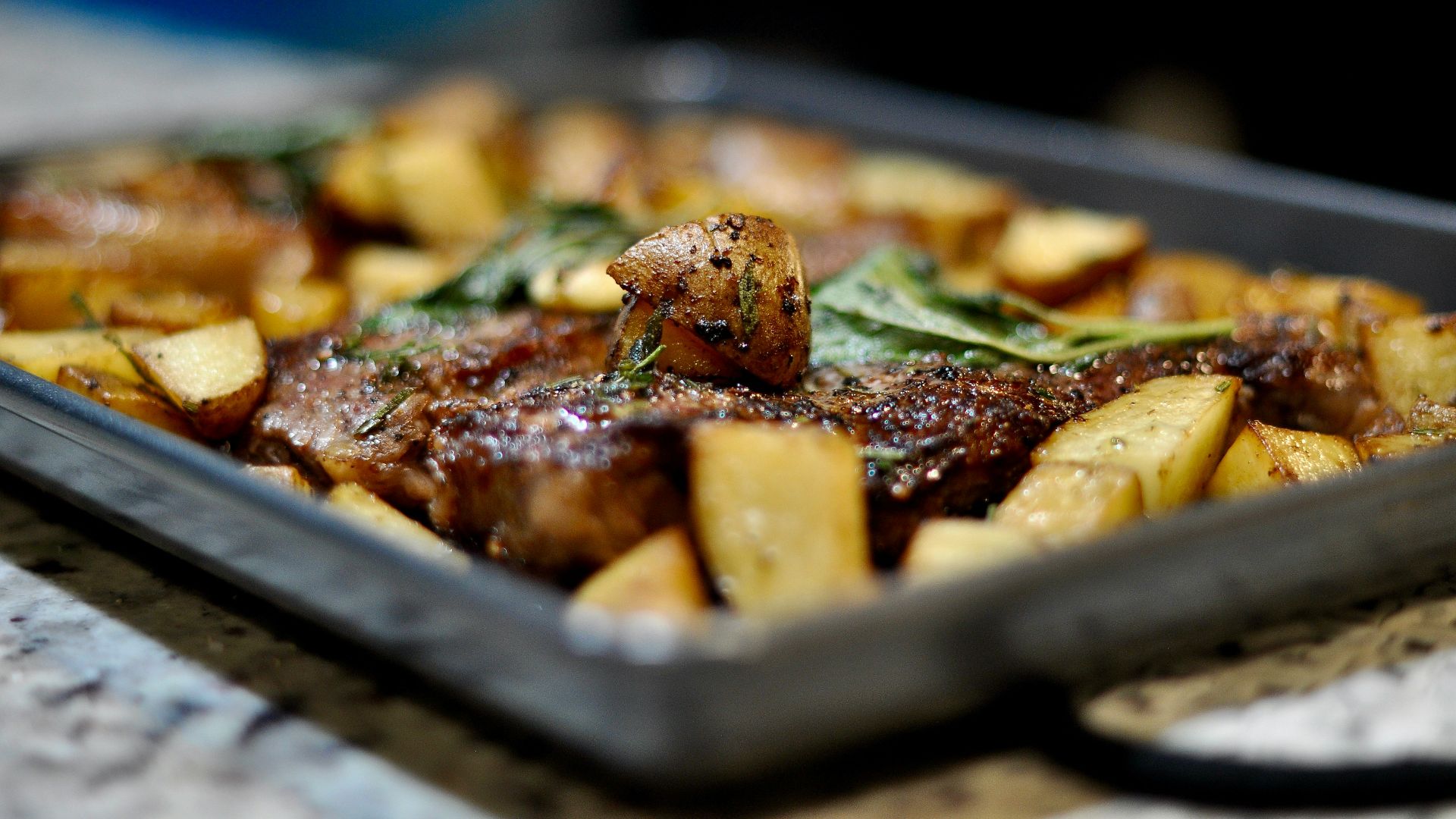 a tray of meat and potatoes on a table