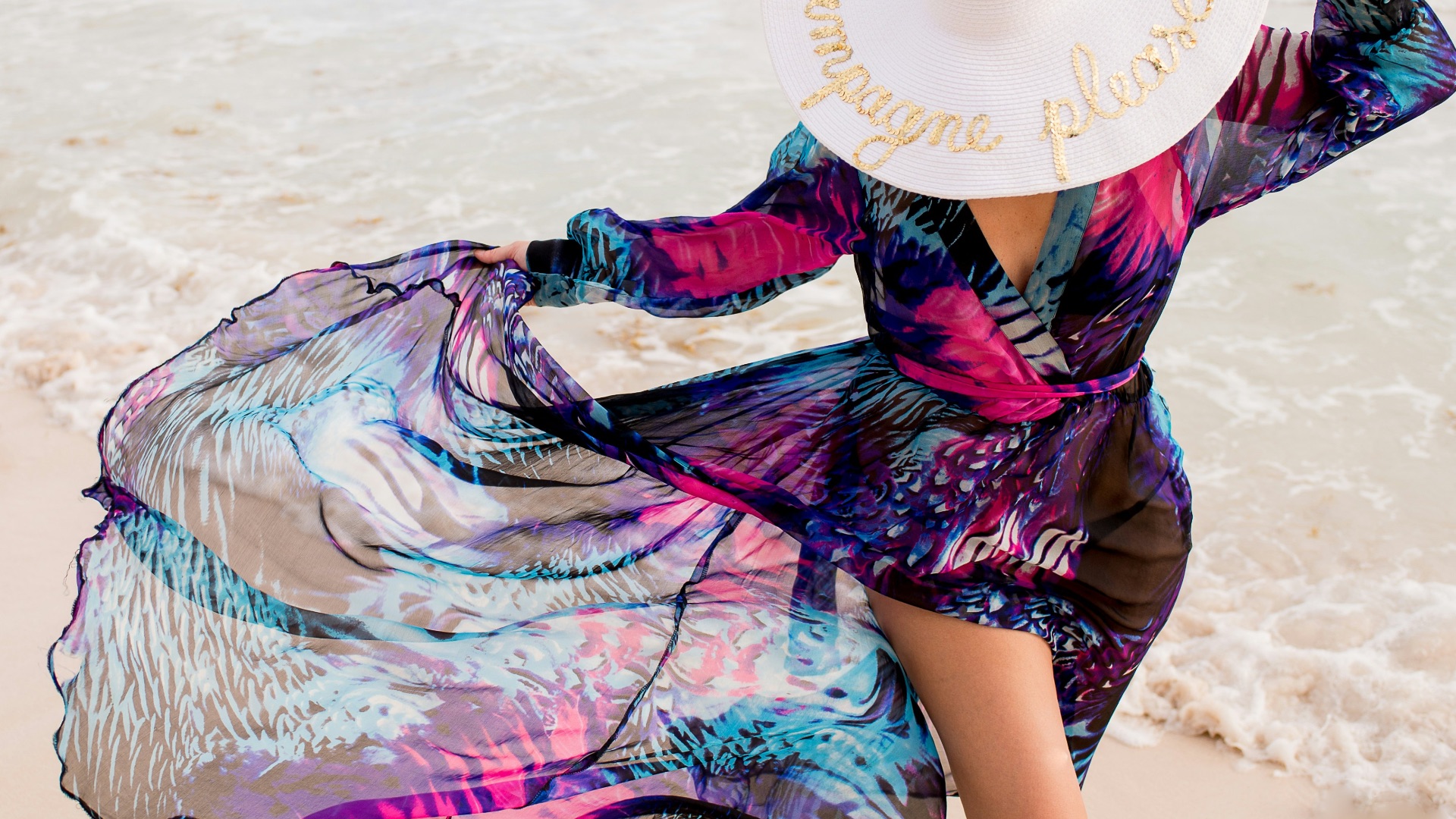 a woman with a hat walking on the beach