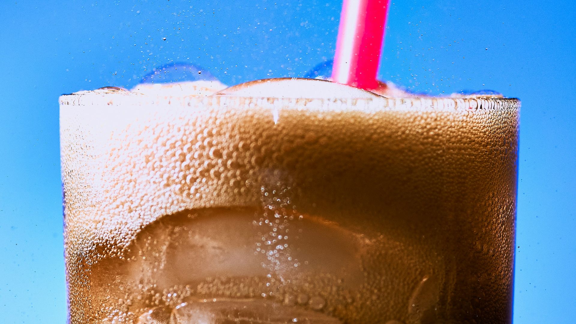 clear drinking glass with ice and red straw