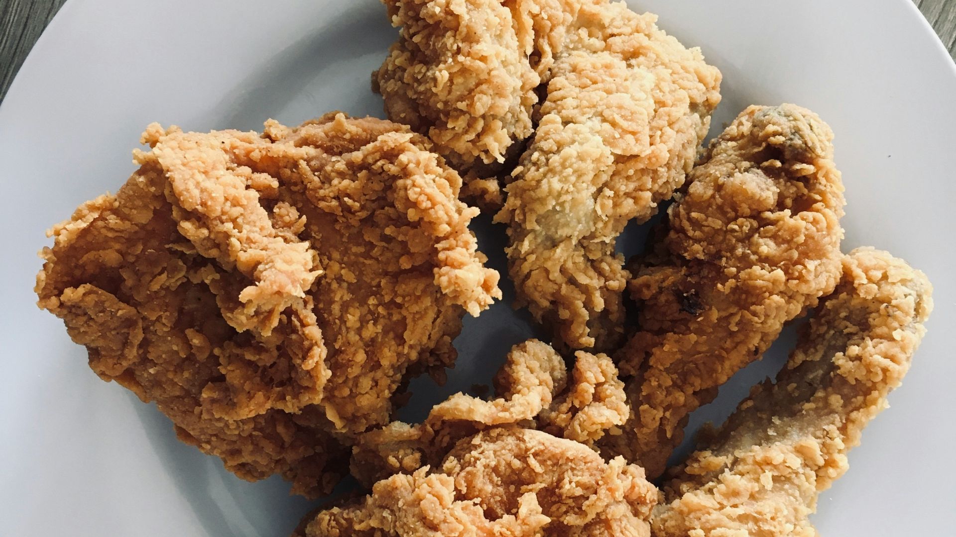 a white plate topped with fried food on top of a wooden table
