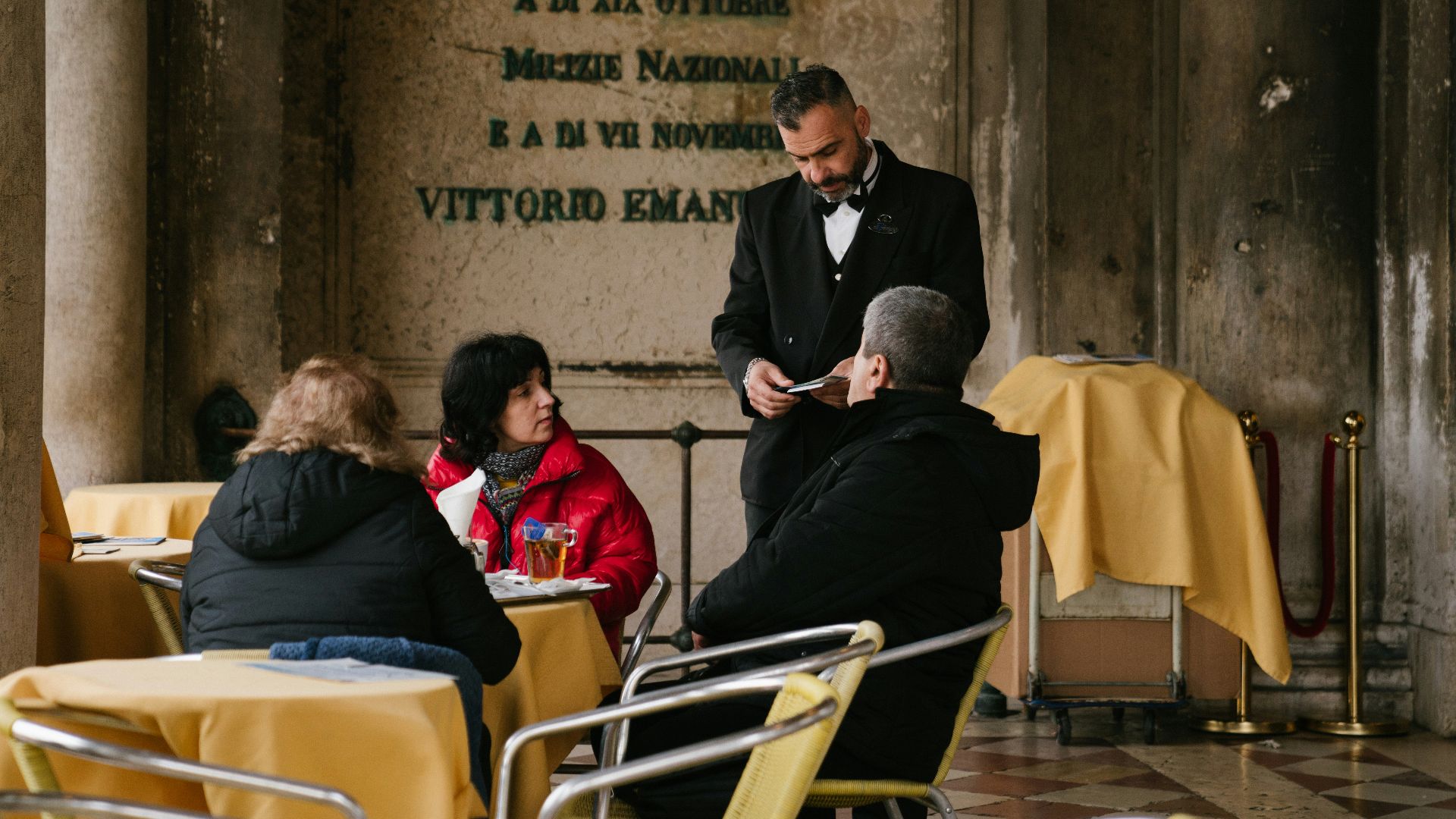 man in black suit sitting on white chair