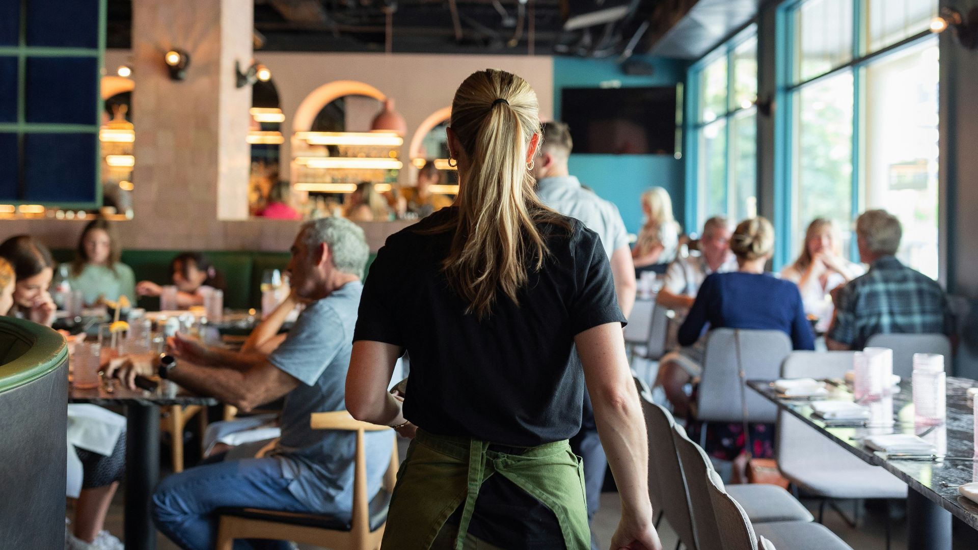 A group of people sitting at tables in a restaurant