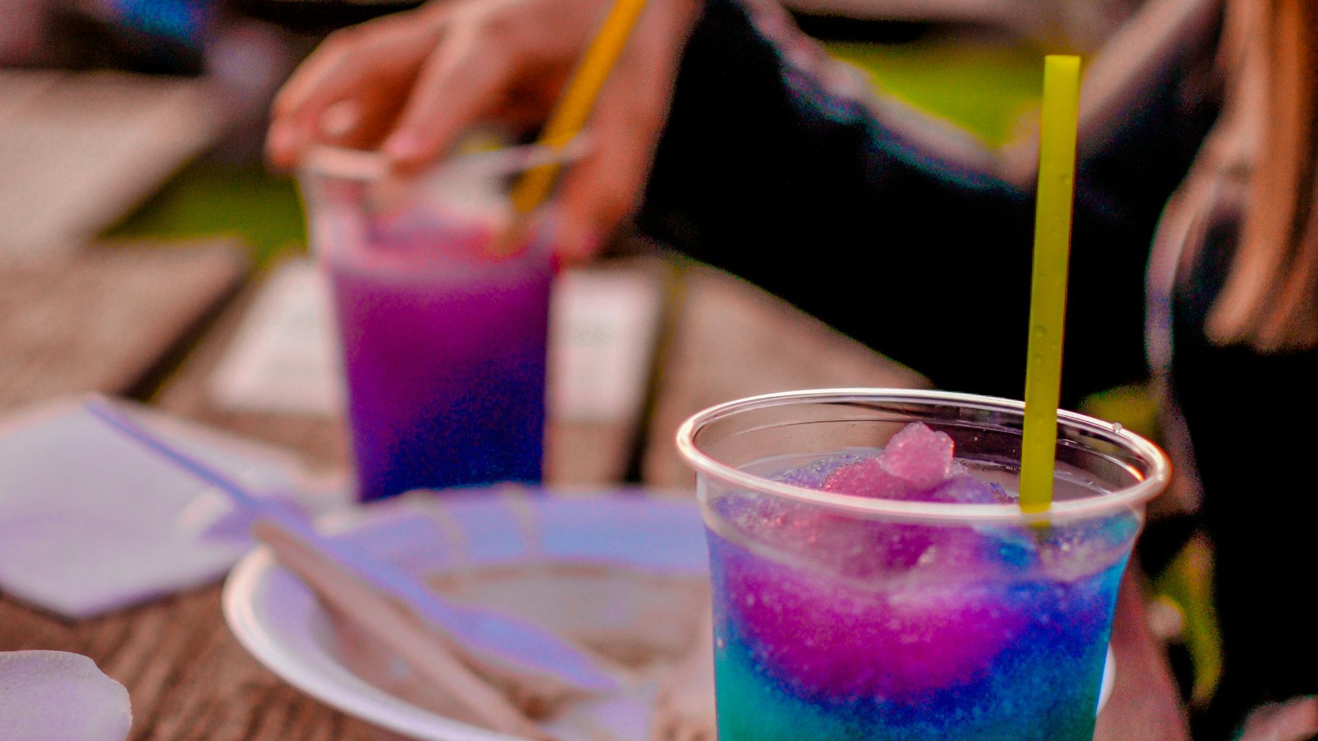a woman sitting at a table with a drink in front of her