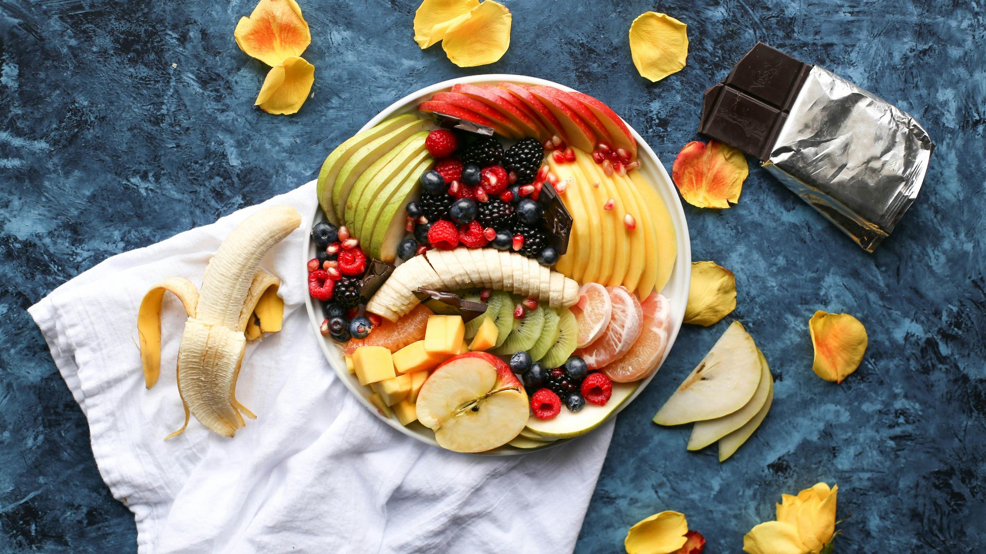 bowl of sliced fruits on white textile