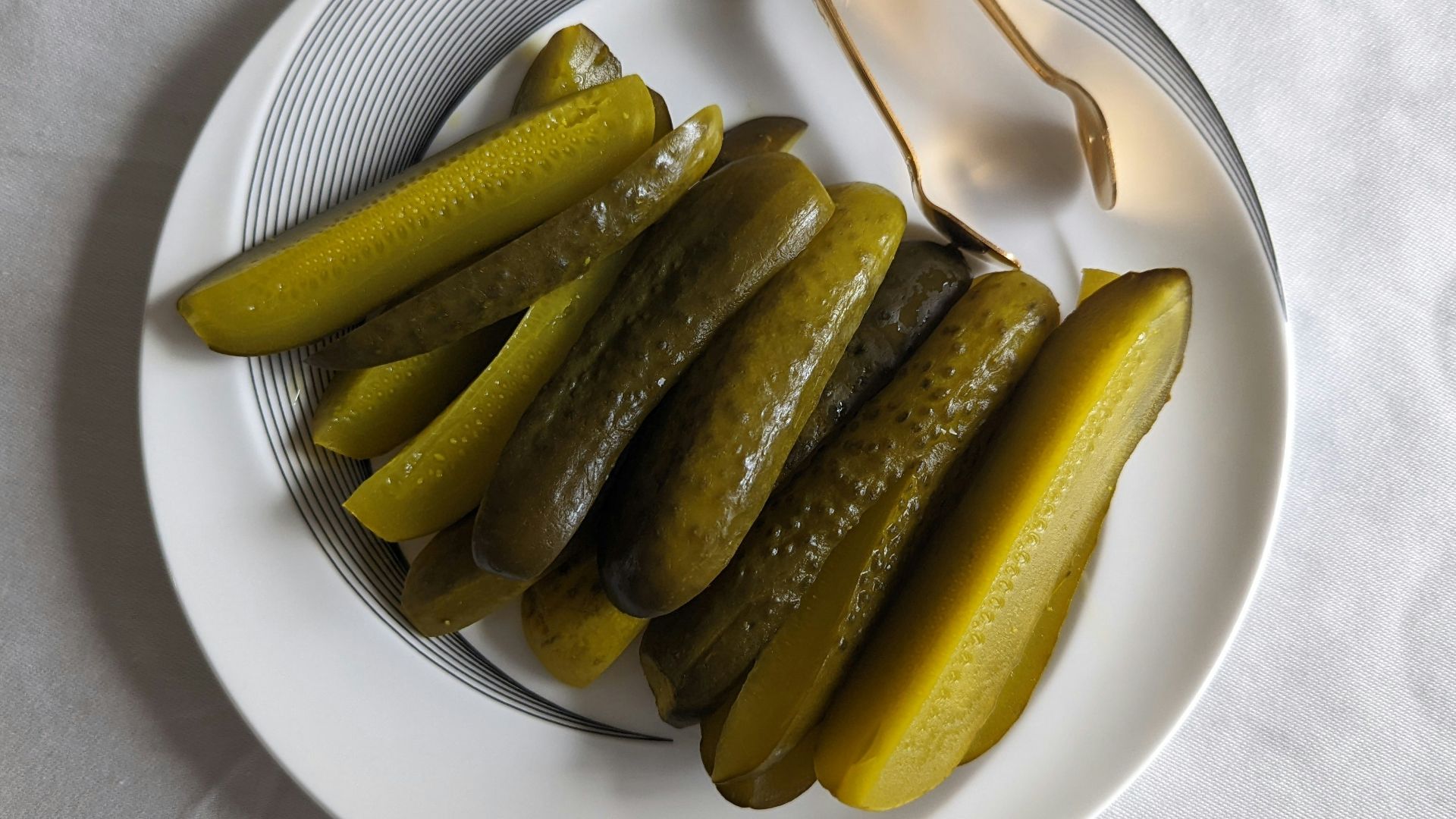 a white plate topped with pickles next to a fork