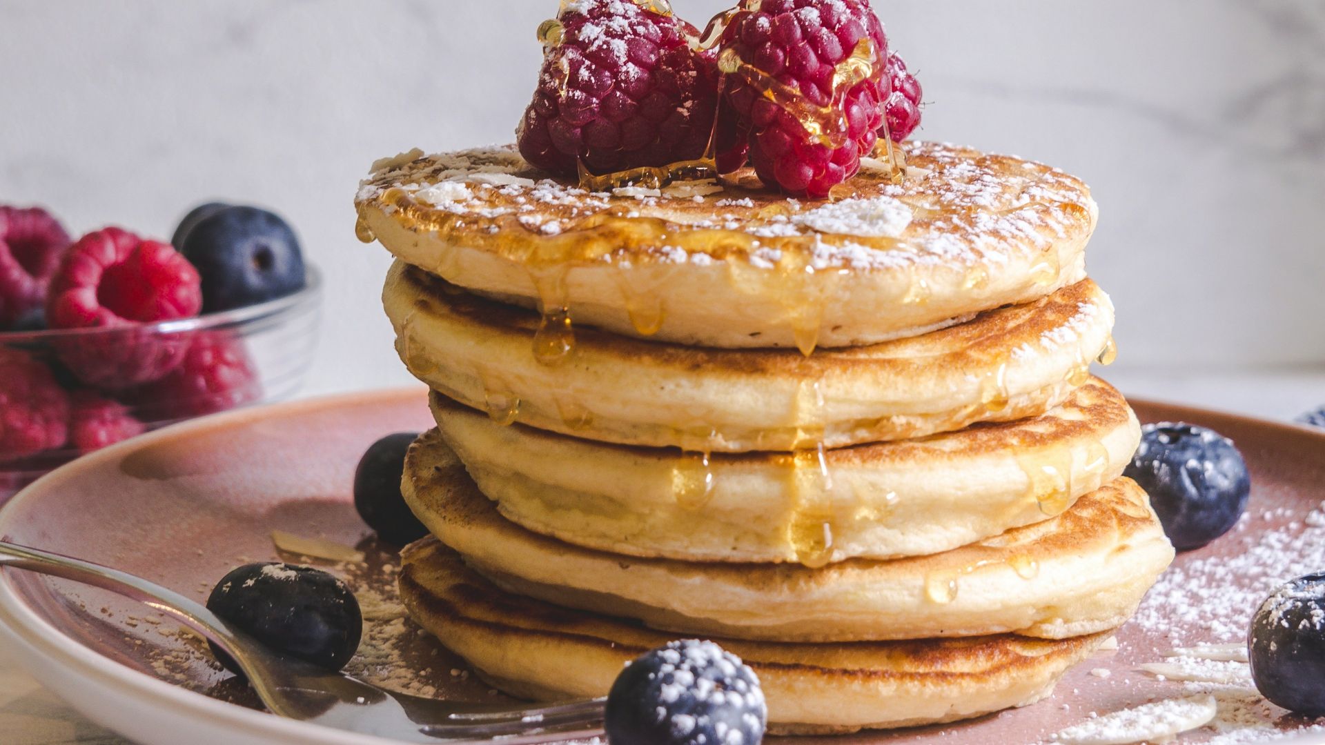 pancakes with berries on white ceramic plate
