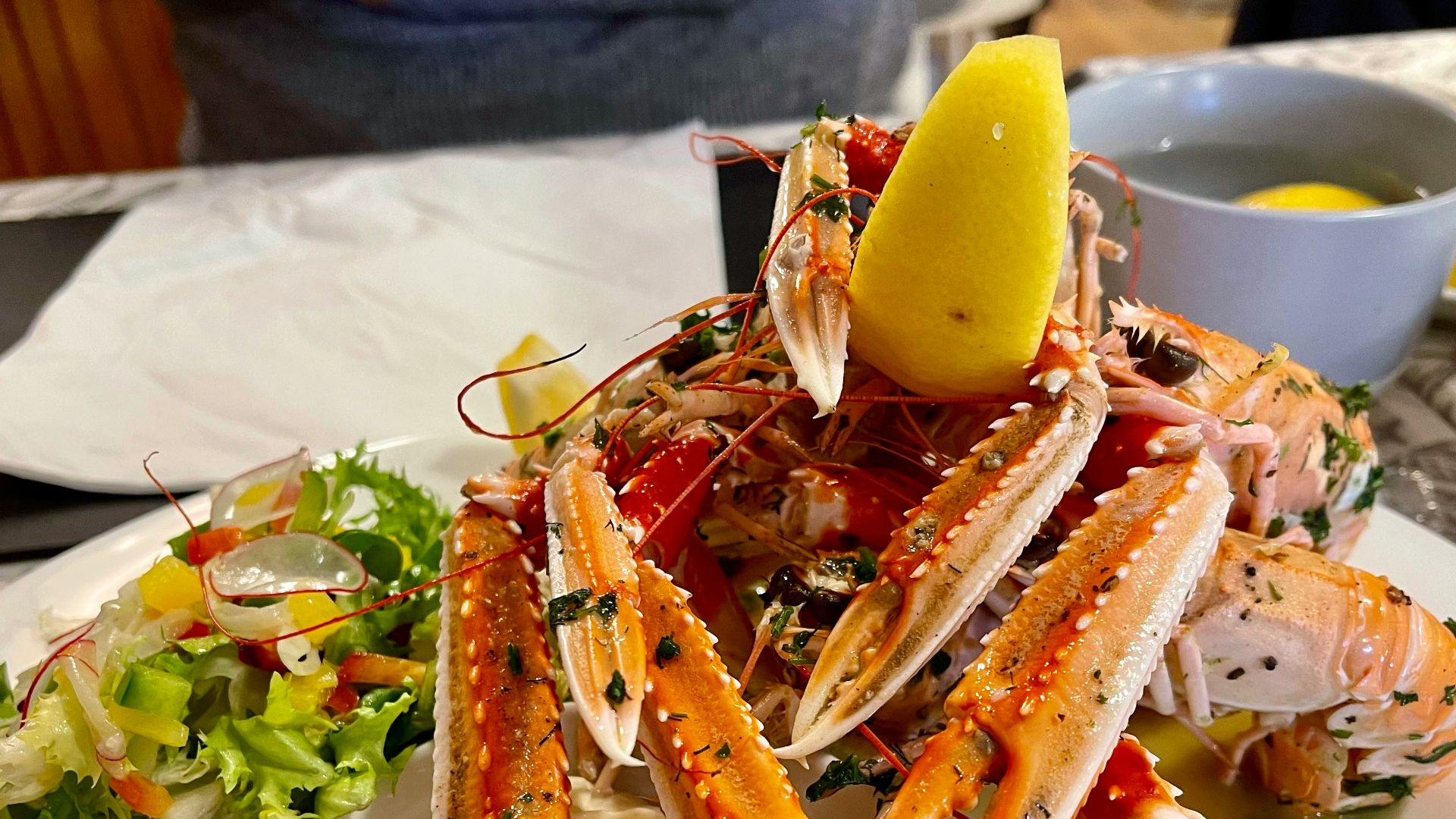 a white plate topped with a pile of crab legs