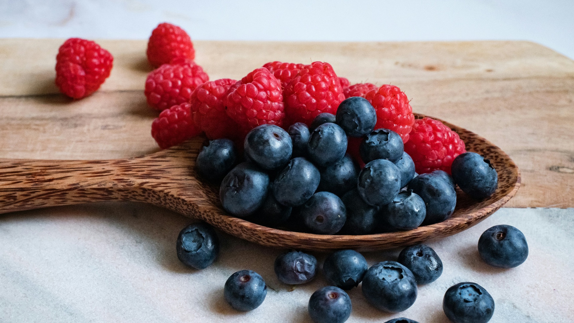 black berries on brown wooden spoon