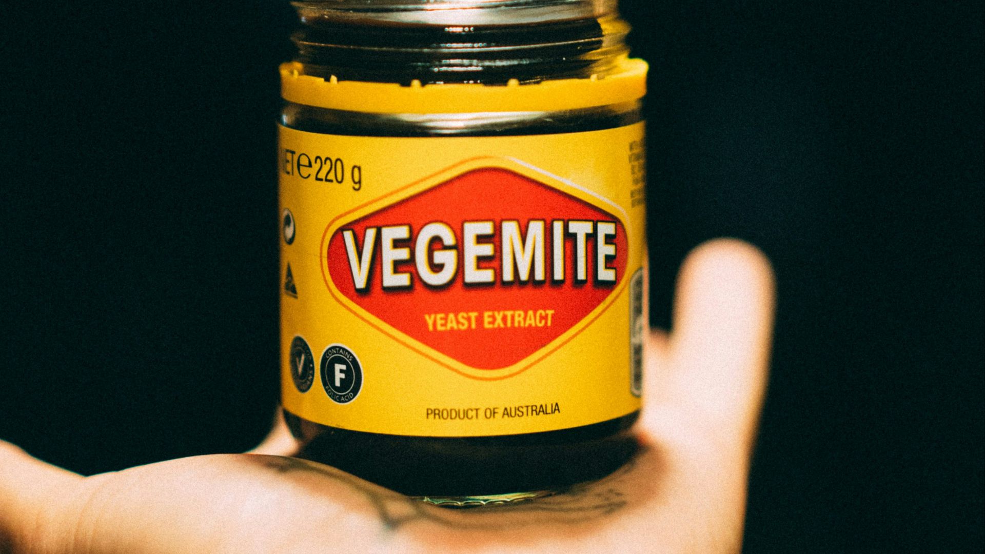 person holding yellow and black bottle