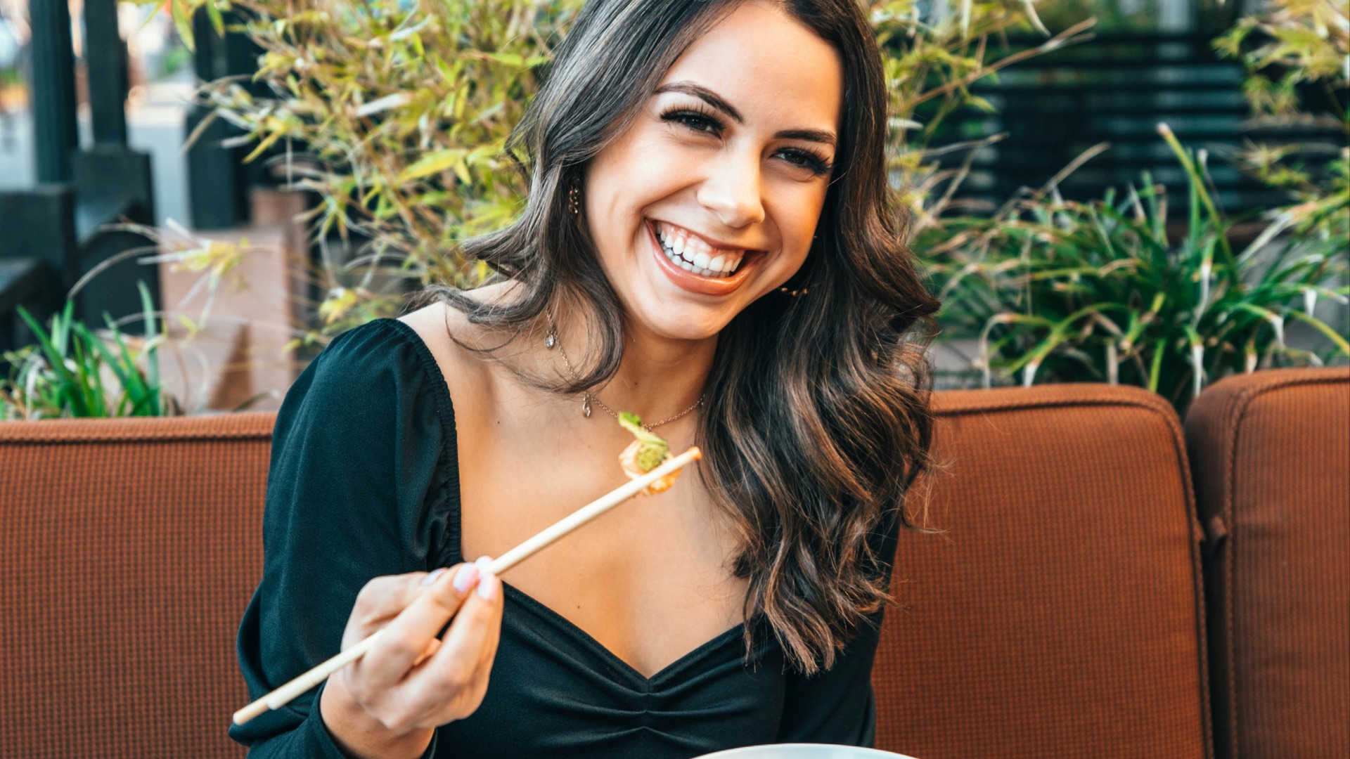 woman in blue long sleeve shirt holding chopsticks
