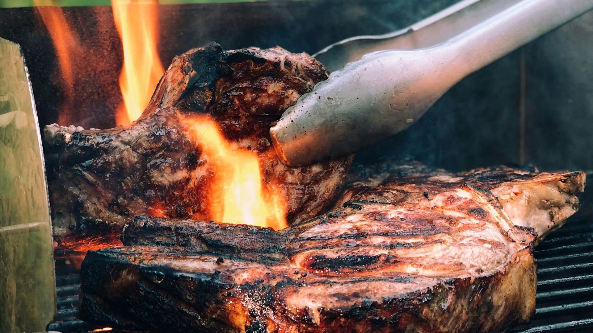 gray metal tong and grilled meat with fire