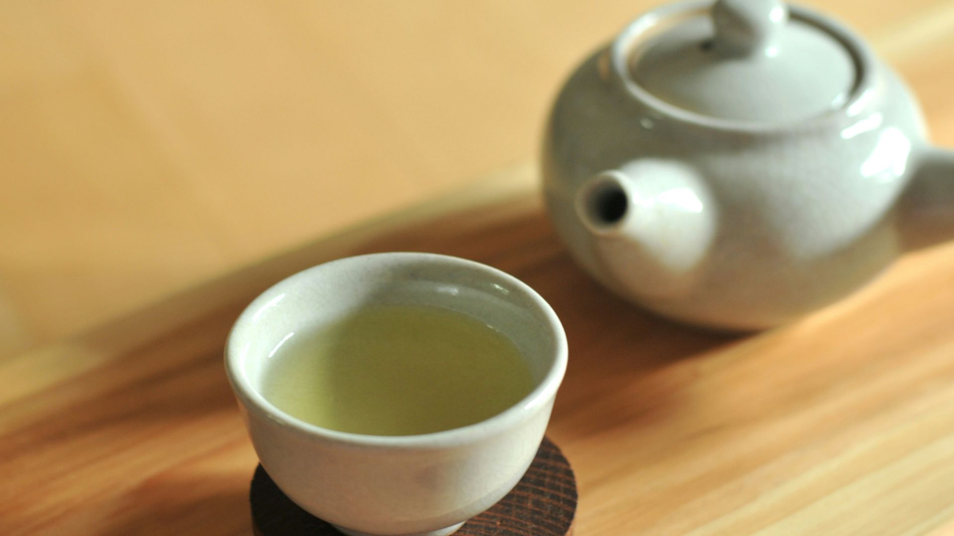 white ceramic teacup on brown wooden table