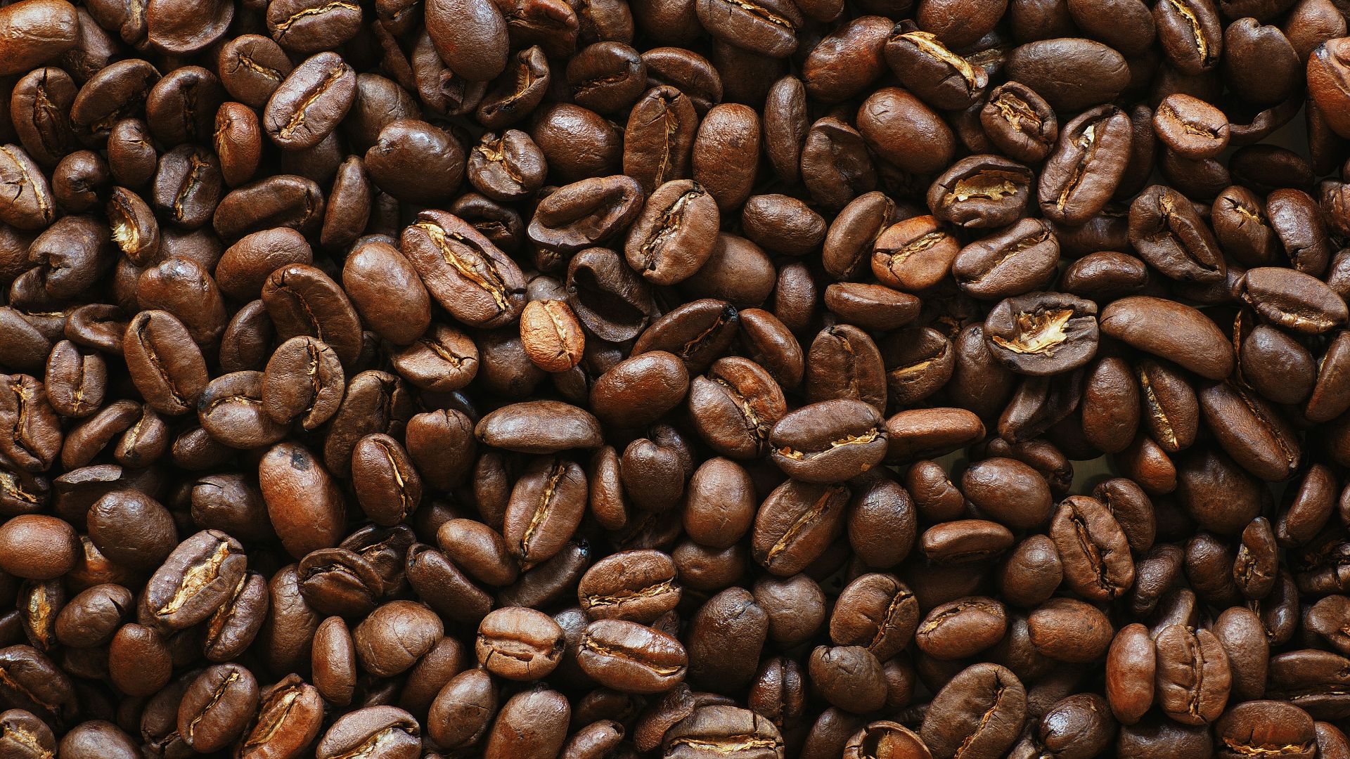 brown coffee beans on black surface