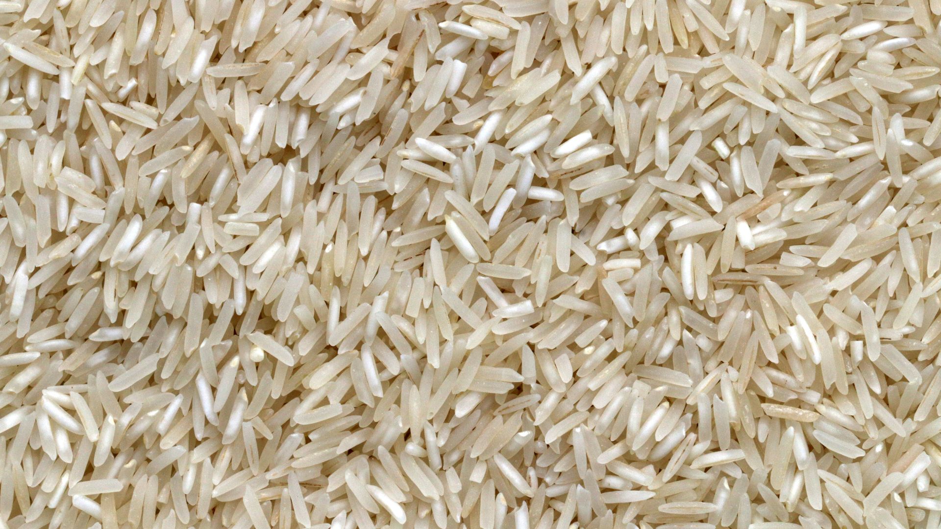 white rice grains on brown wooden table