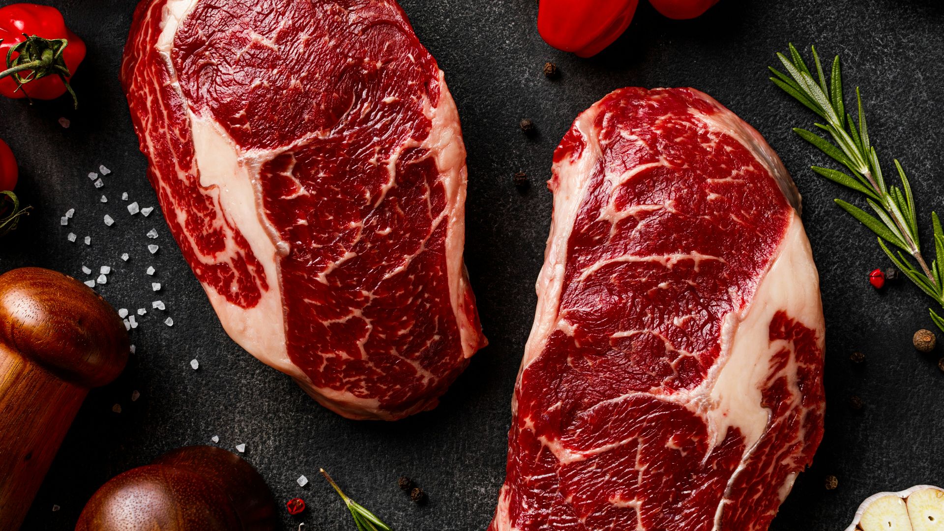 a couple of steaks sitting on top of a table