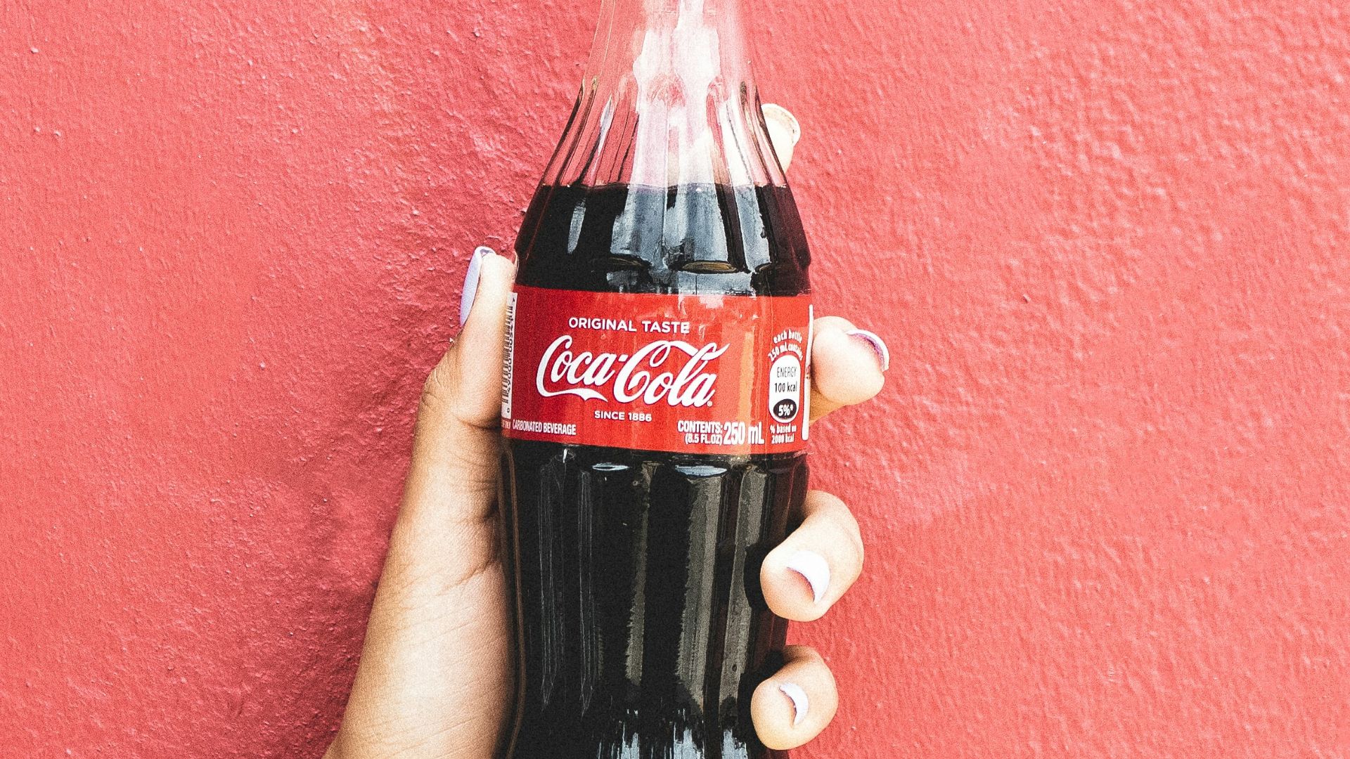 coca cola bottle on persons hand