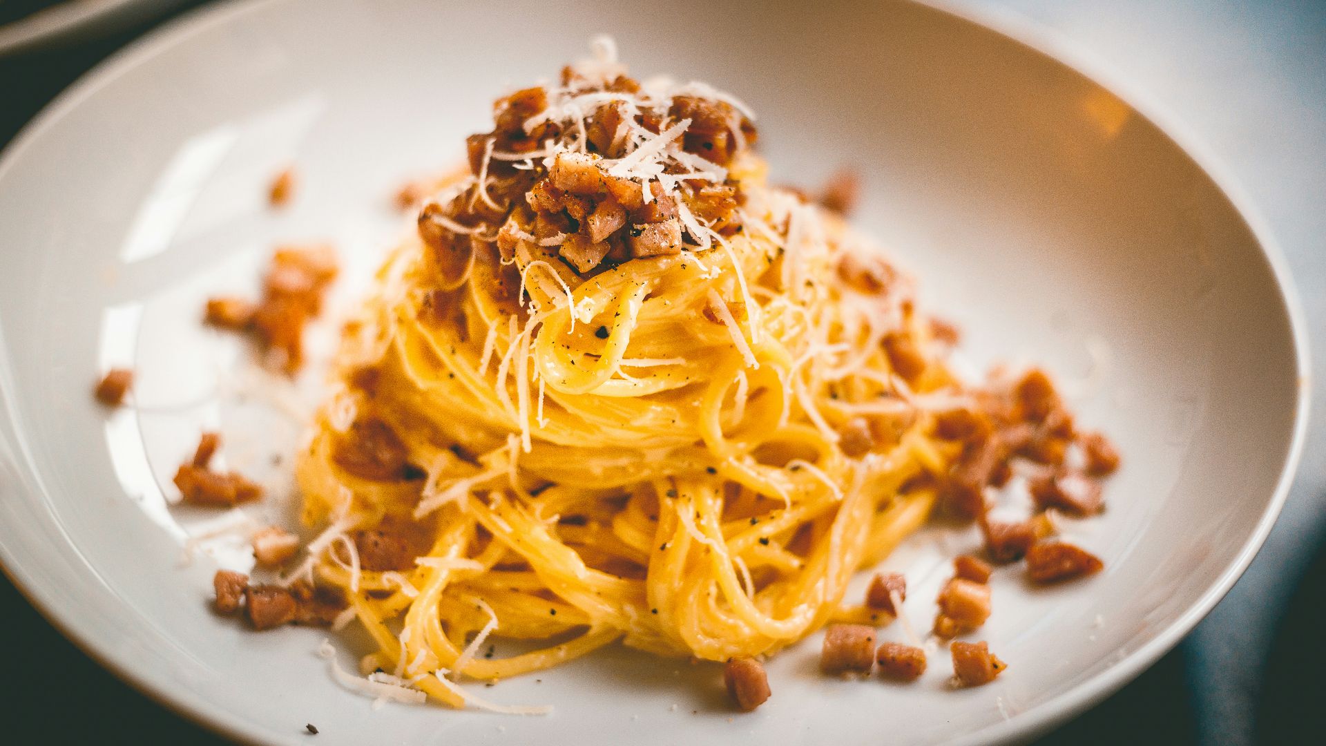 a white plate topped with spaghetti and bacon