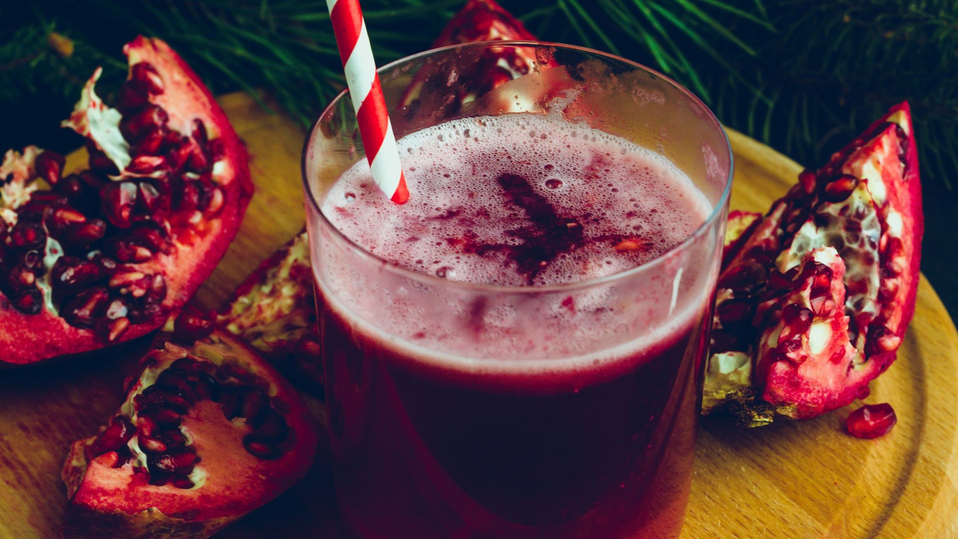 clear drinking glass with red liquid on brown wooden round table