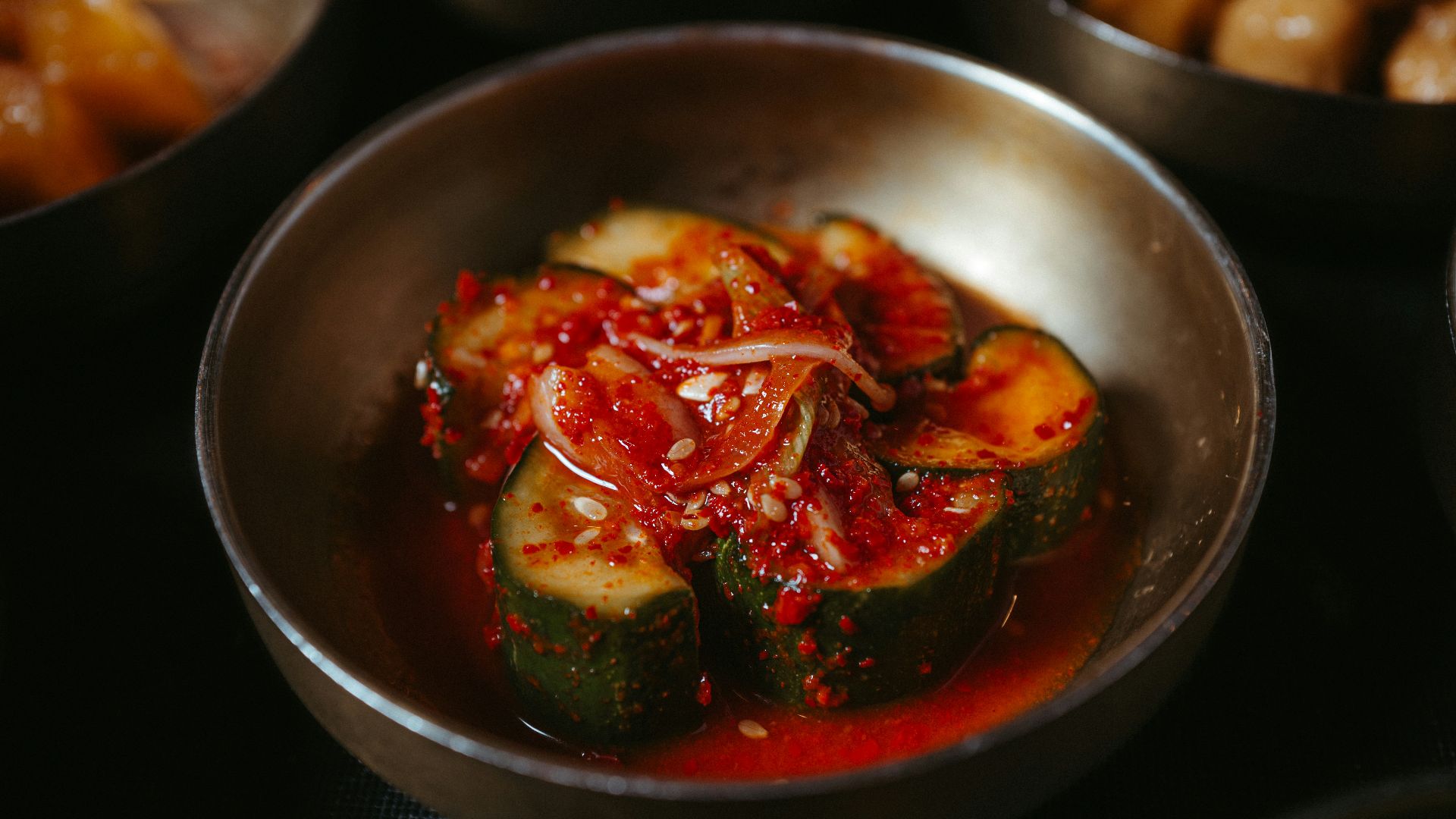 a table topped with metal bowls filled with food