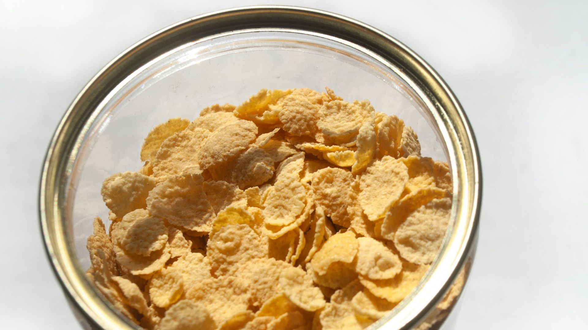 Corn flakes are in a glass jar.