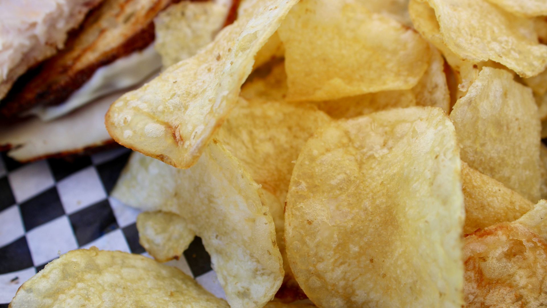 Crispy potato chips piled on checkered paper