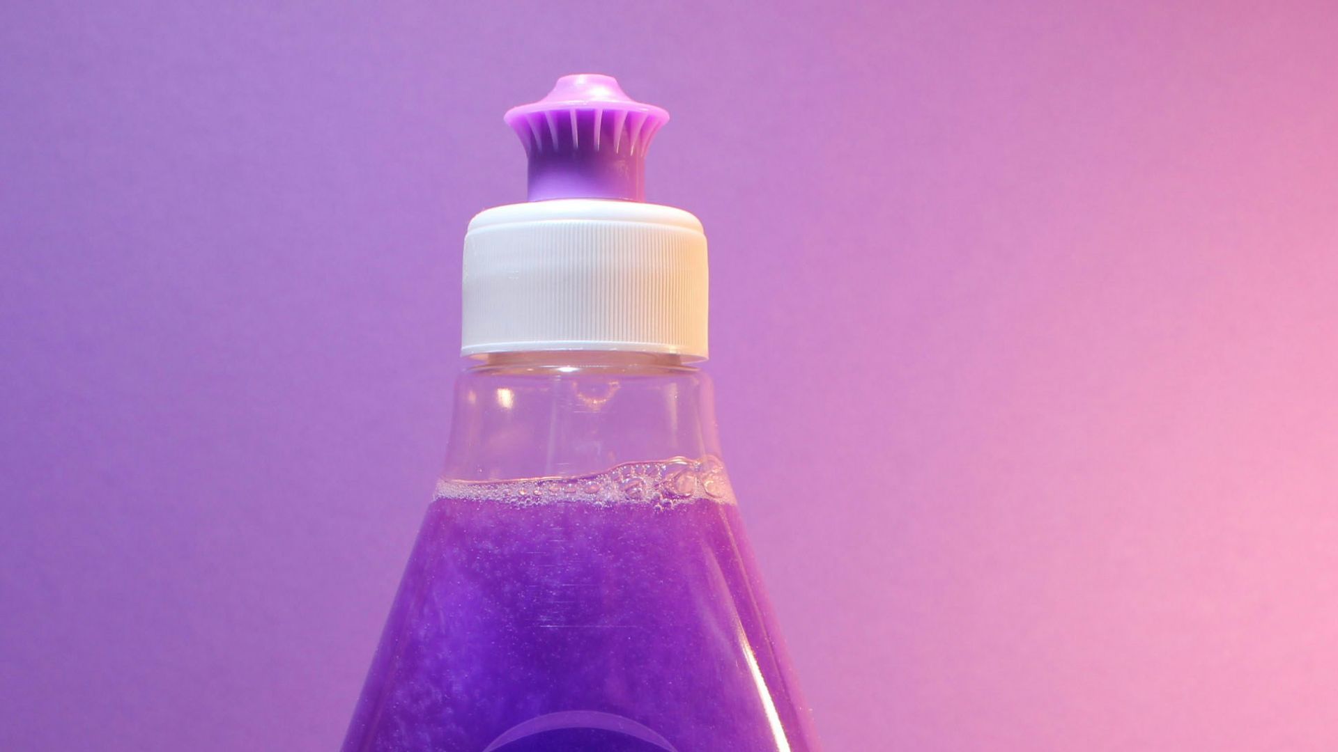 a bottle of purple liquid sitting on top of a table