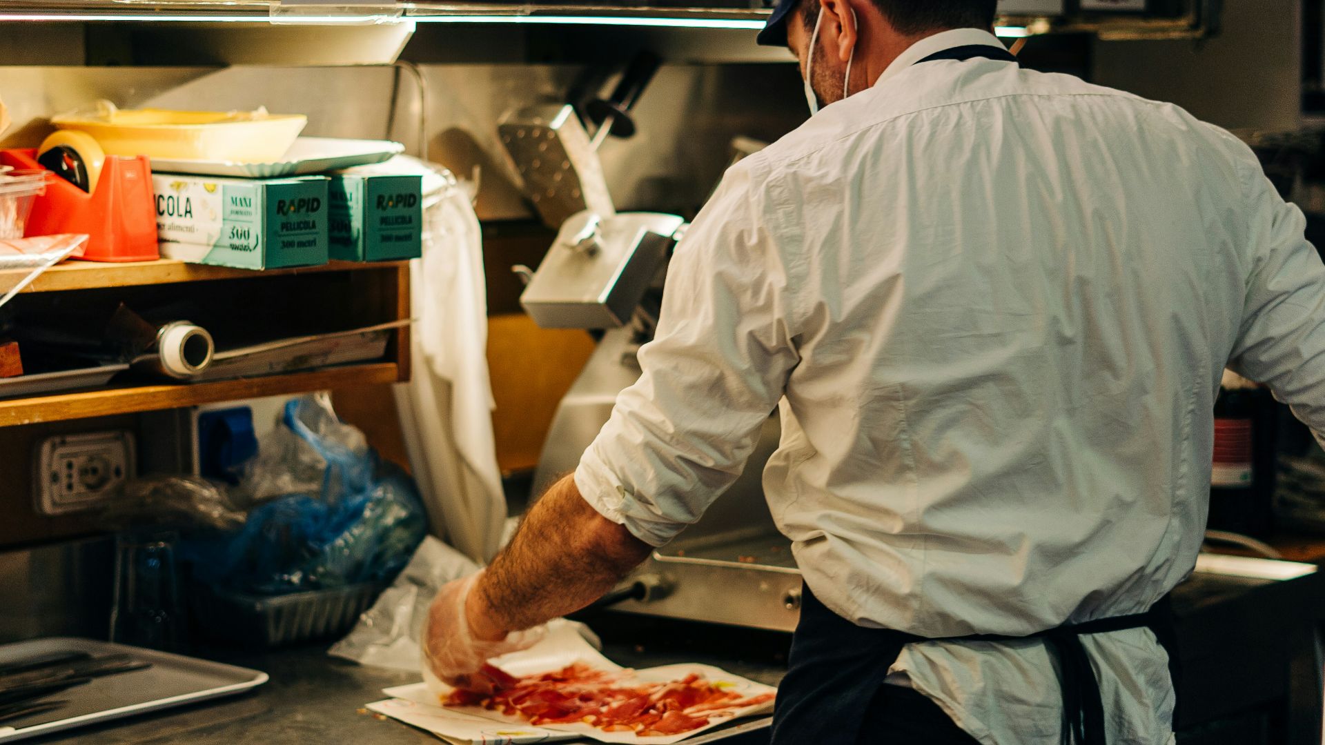 man in white dress shirt standing in front of raw meat