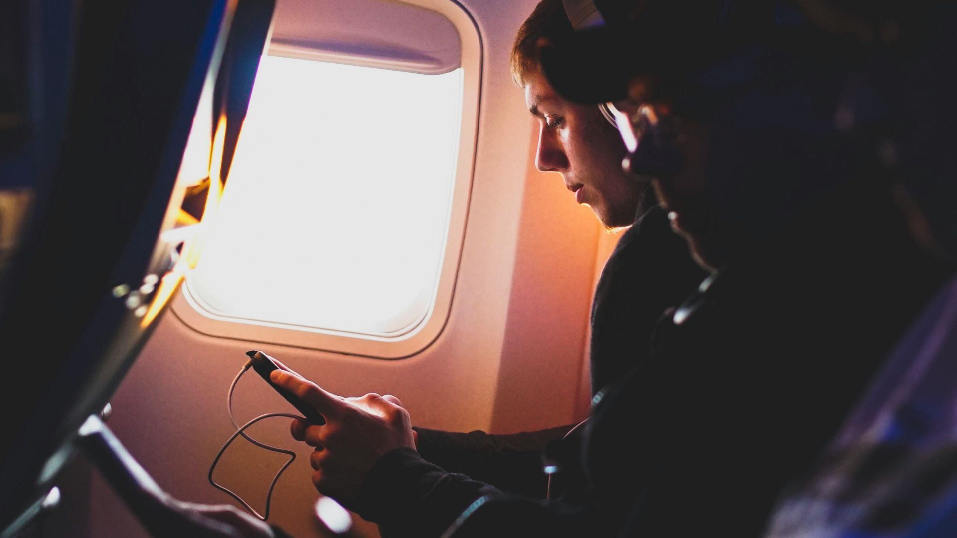 photo of three people listening to music inside airplane
