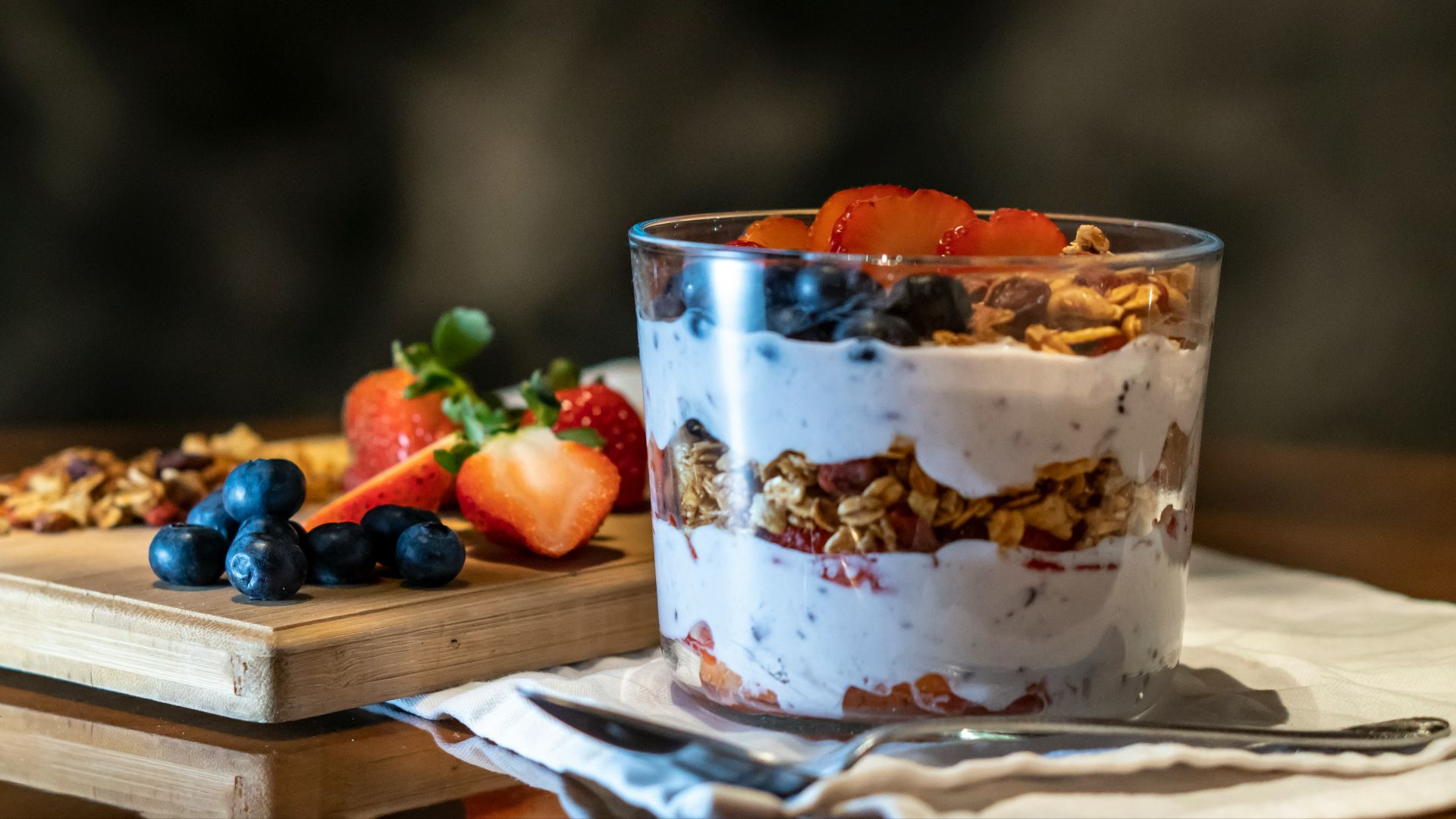 strawberries and cookies with cream filled dessert in glass cup