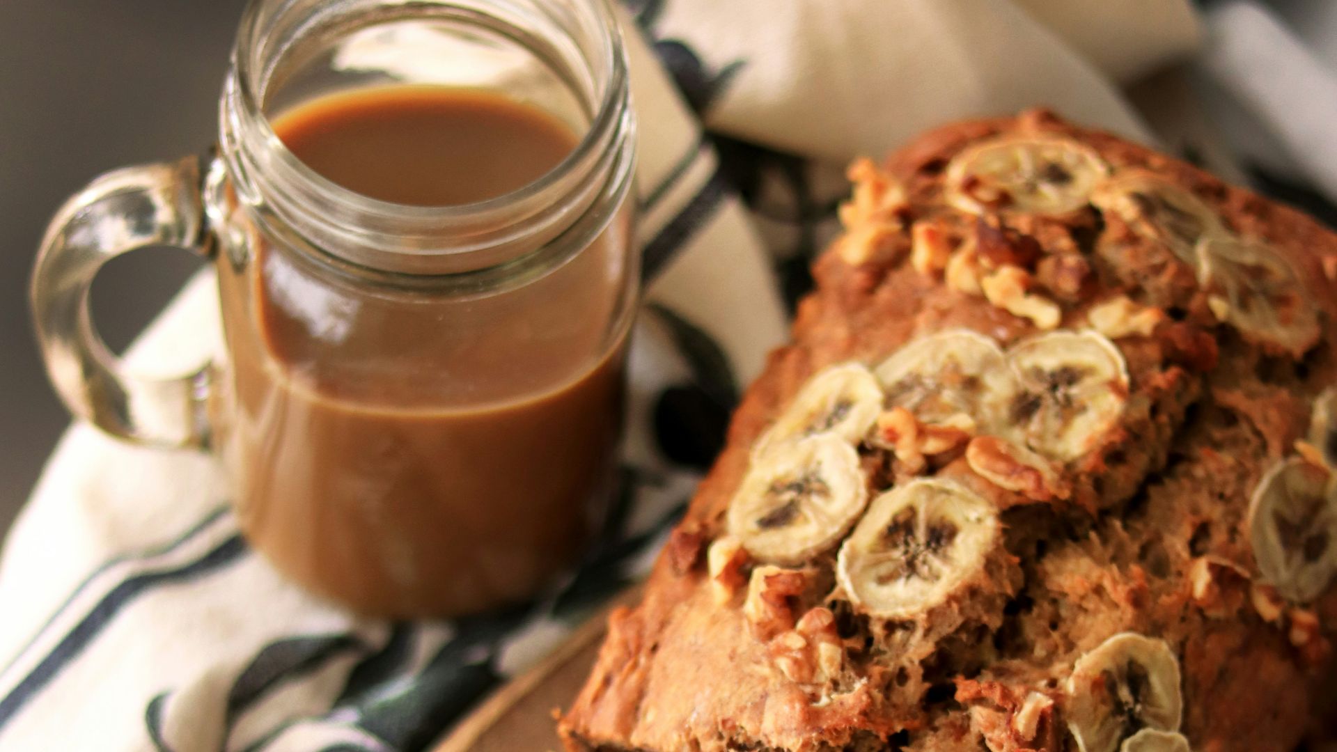 a loaf of banana nut bread sitting on top of a wooden cutting board