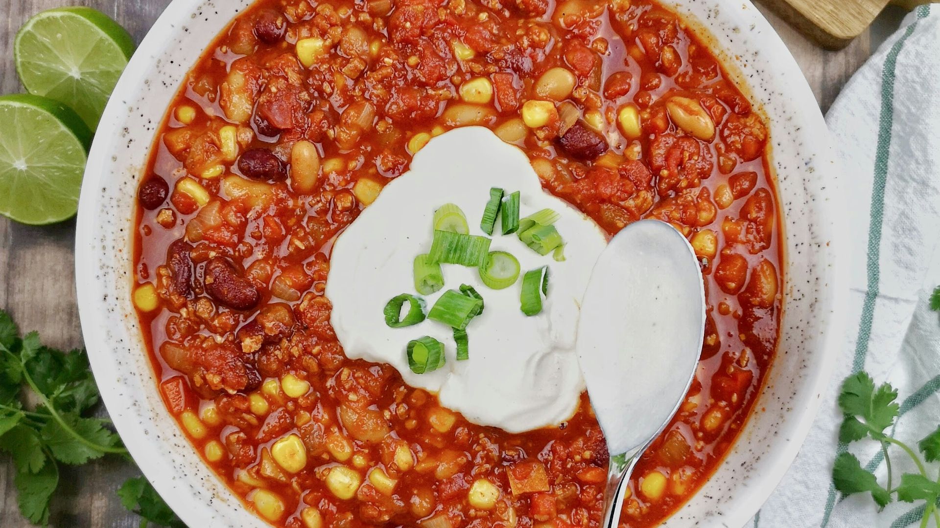 a bowl of chili with sour cream on top