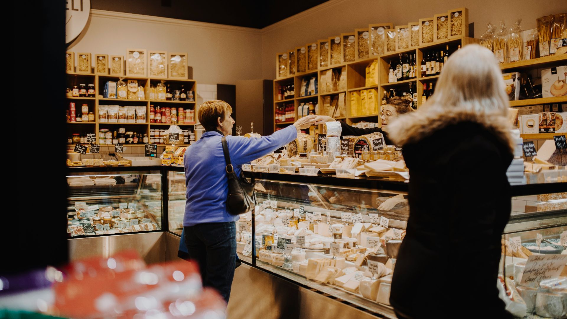 man in blue jacket standing in front of counter