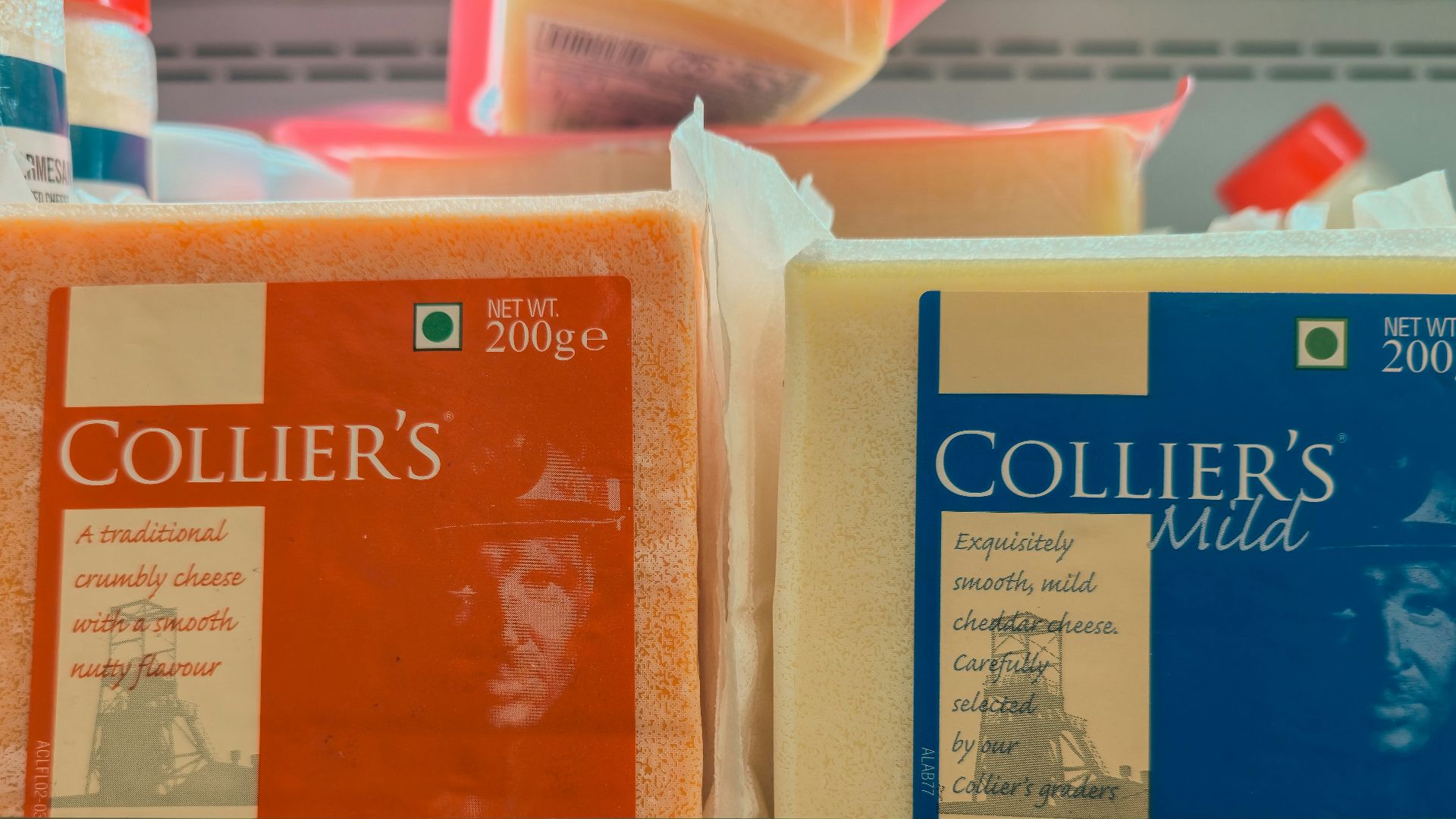 Two blocks of collier's cheese on a shelf.