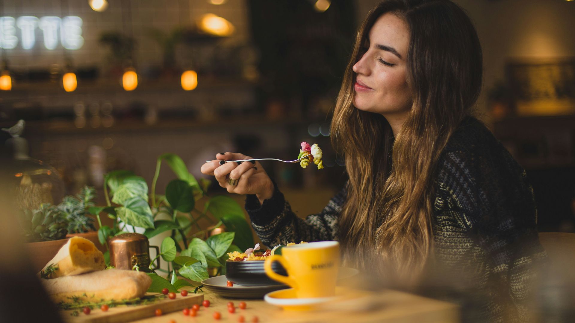 woman holding fork in front table
