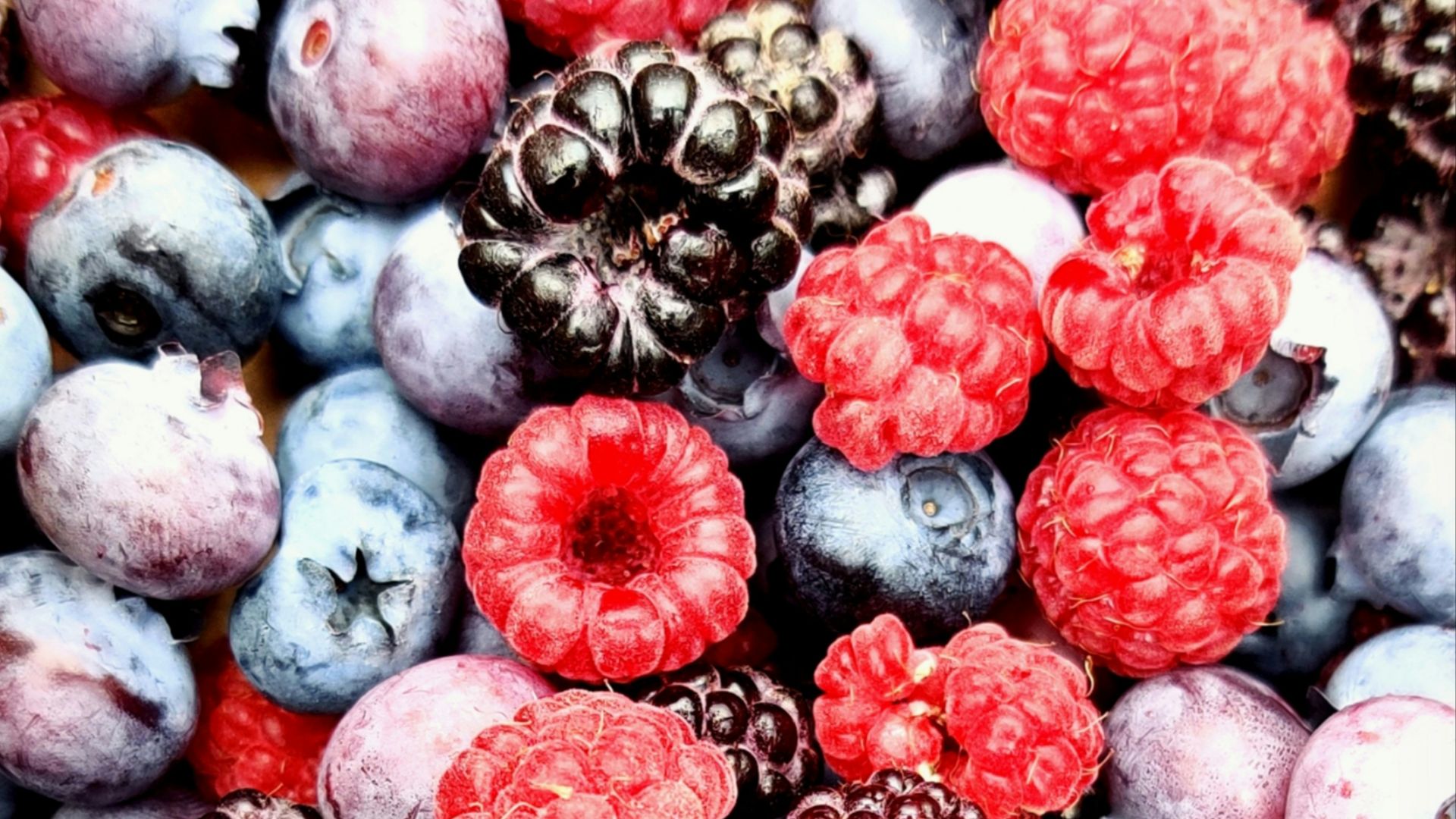 red and black berries on black surface
