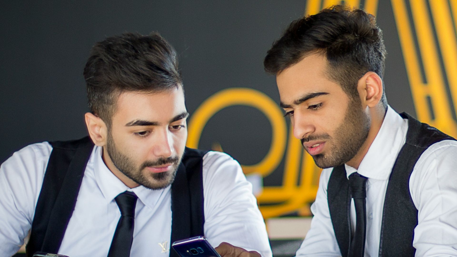 2 men in white dress shirt sitting at the table