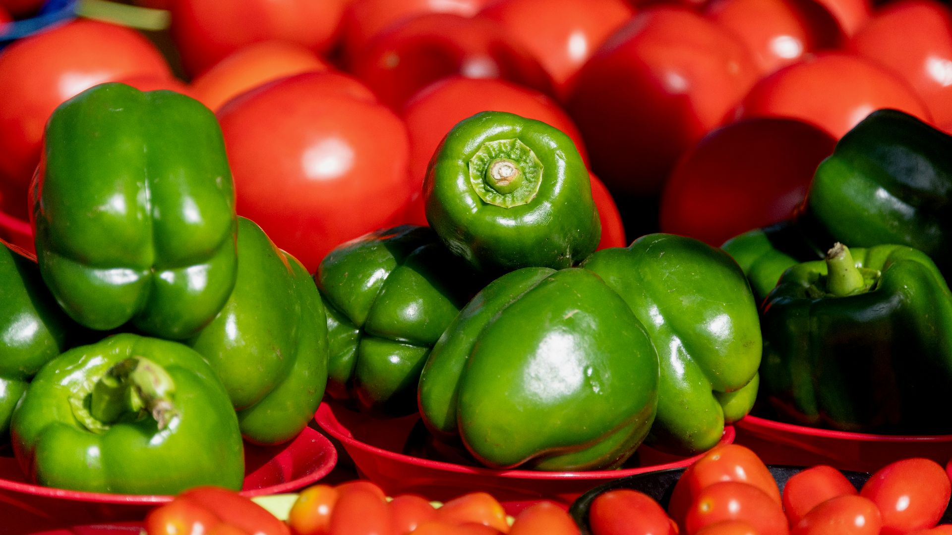 a pile of red and green peppers and tomatoes