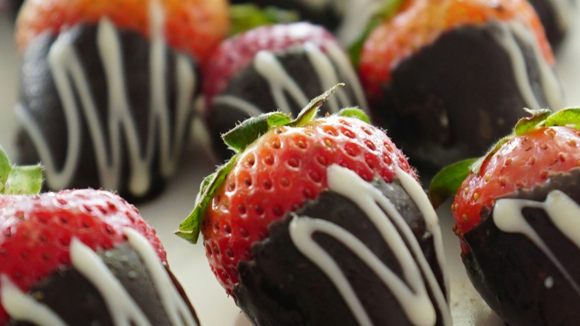 a plate of chocolate covered strawberries on a table