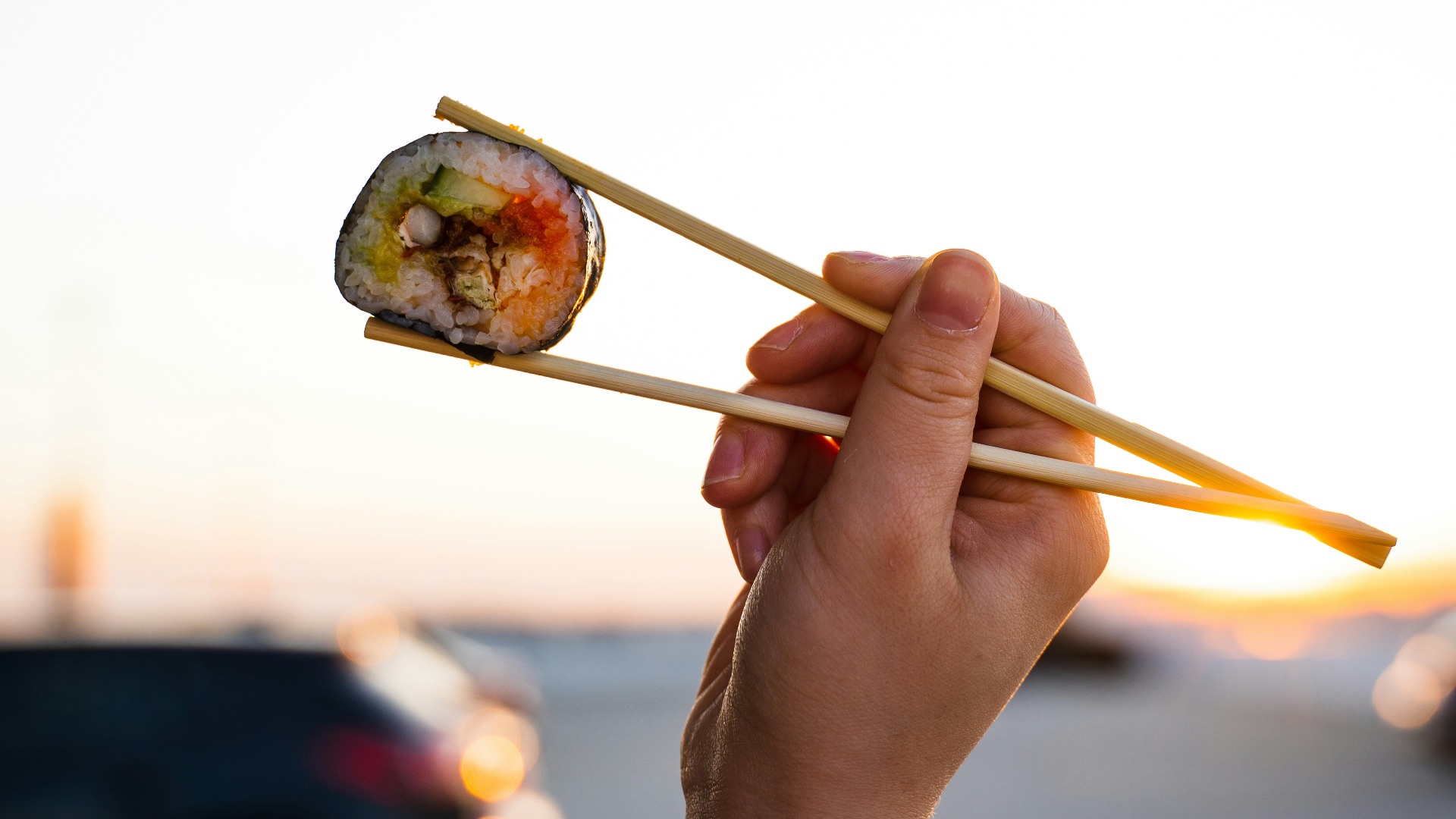person holding brown wooden chopsticks