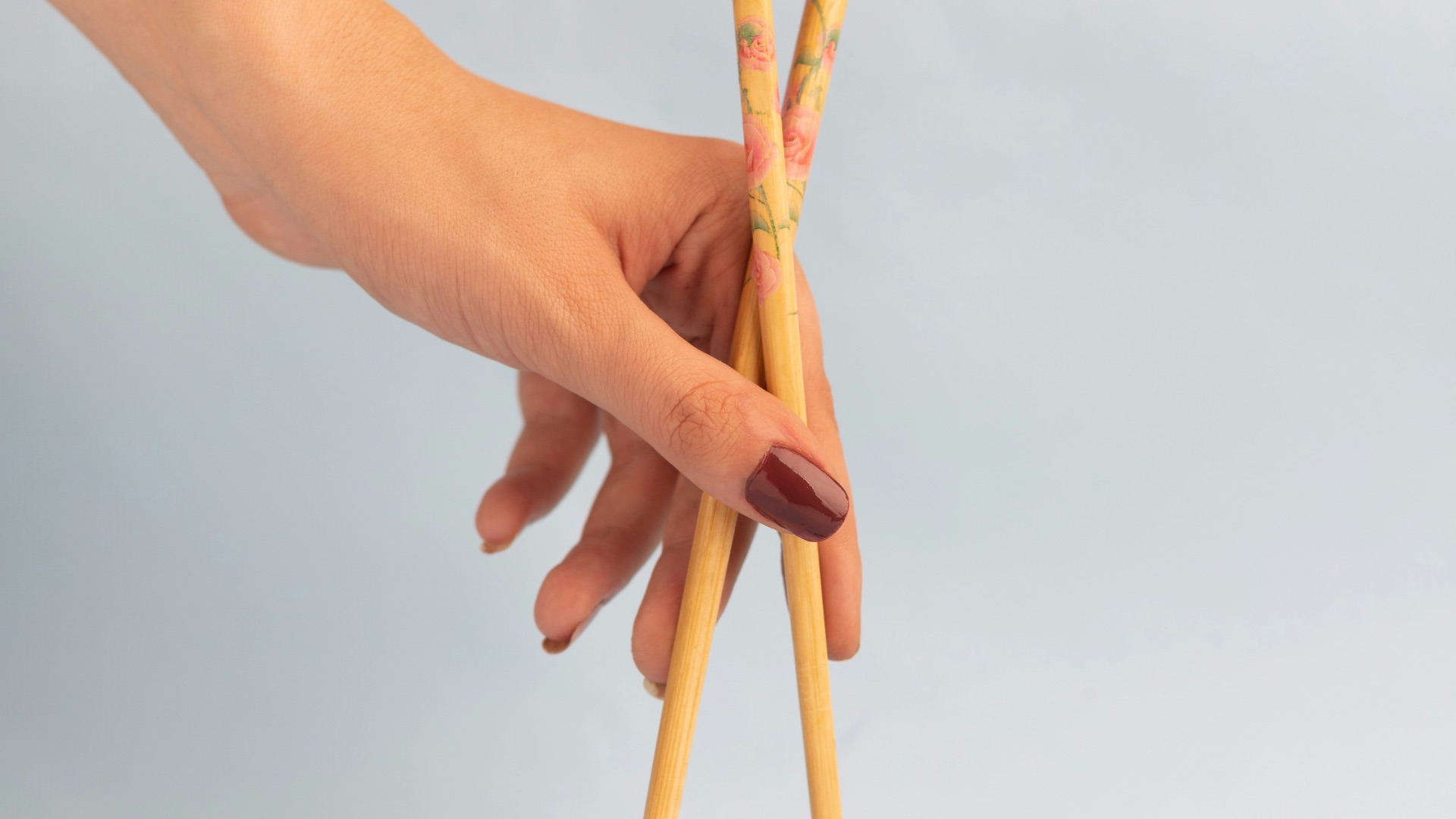 a hand holding a stick with a coin and a coin