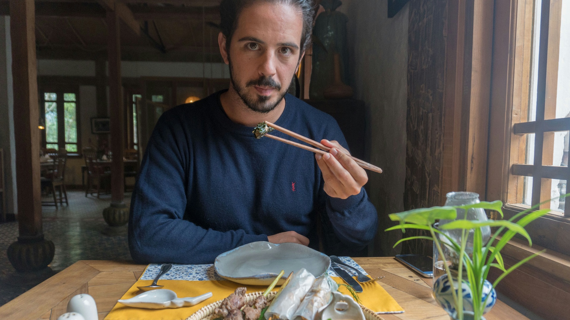 A man sitting at a table with a plate of food